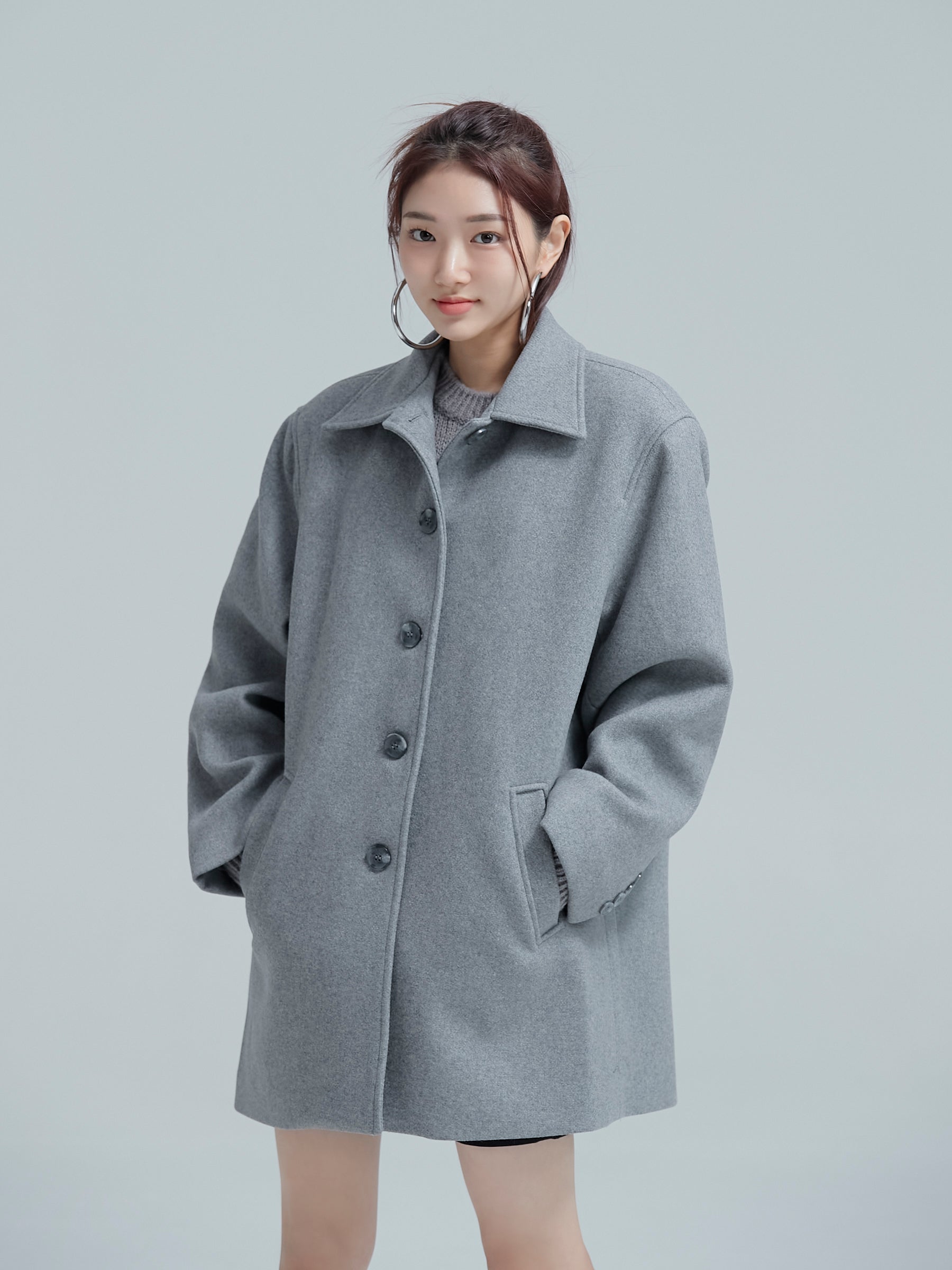 Side angle of the model wearing the 100% Wool Coat showing its intricate designs.