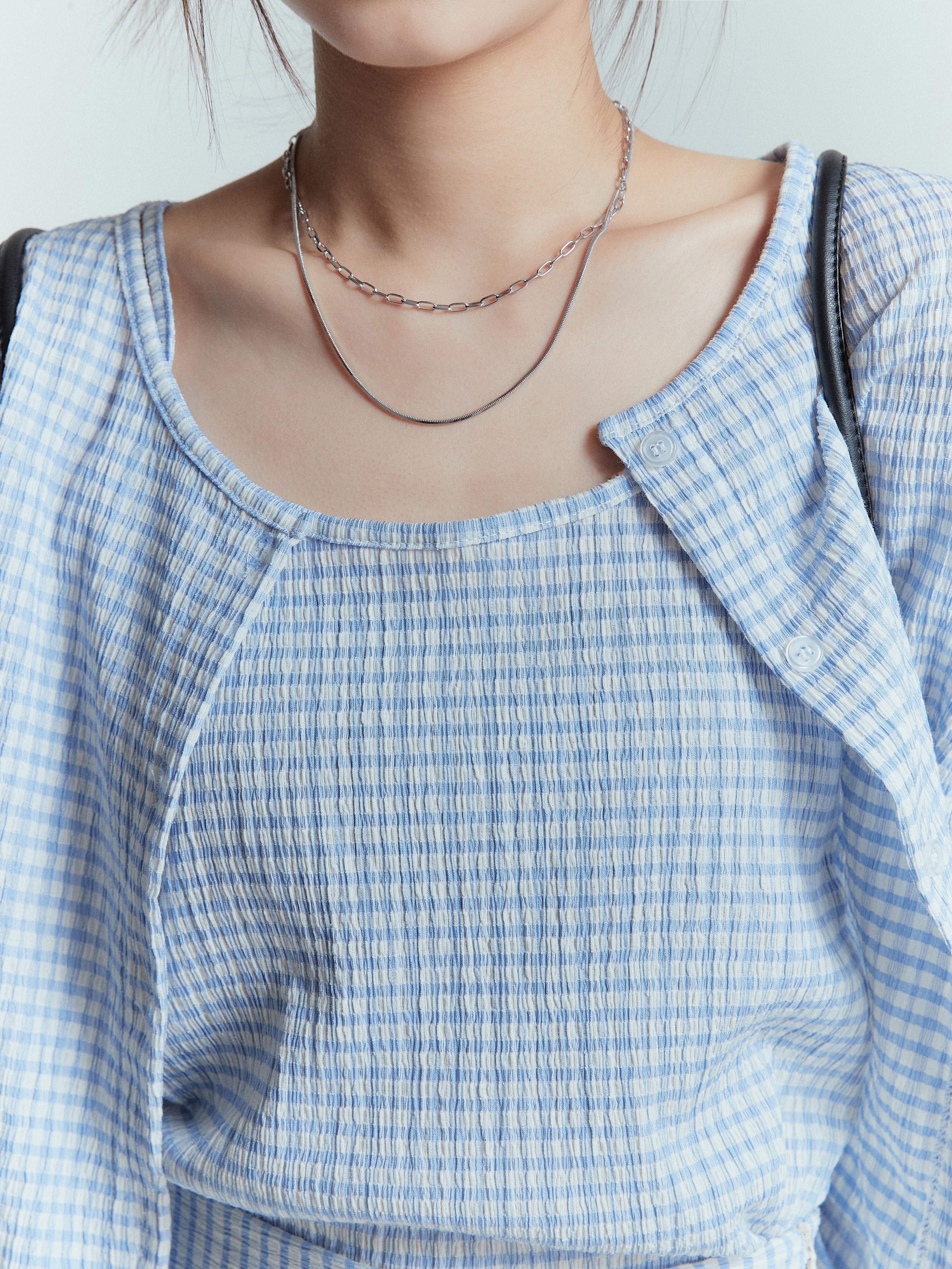 Up-close detailed shot of the model focusing on the top part wearing the plaid cardigan with plaid sleeveless tank top.