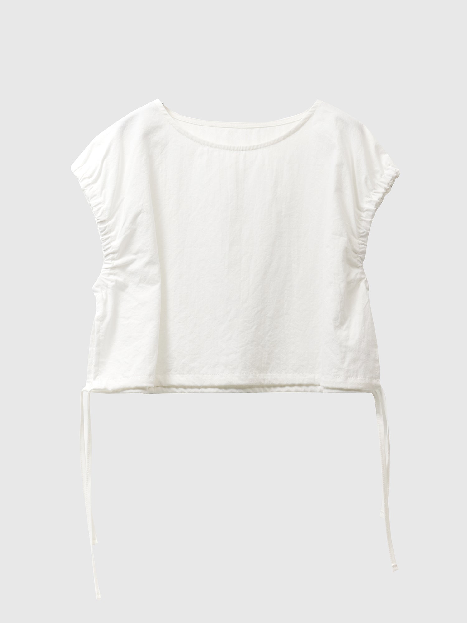 Product detailed shot of a ivory elastic waist crop top with white backdrop.