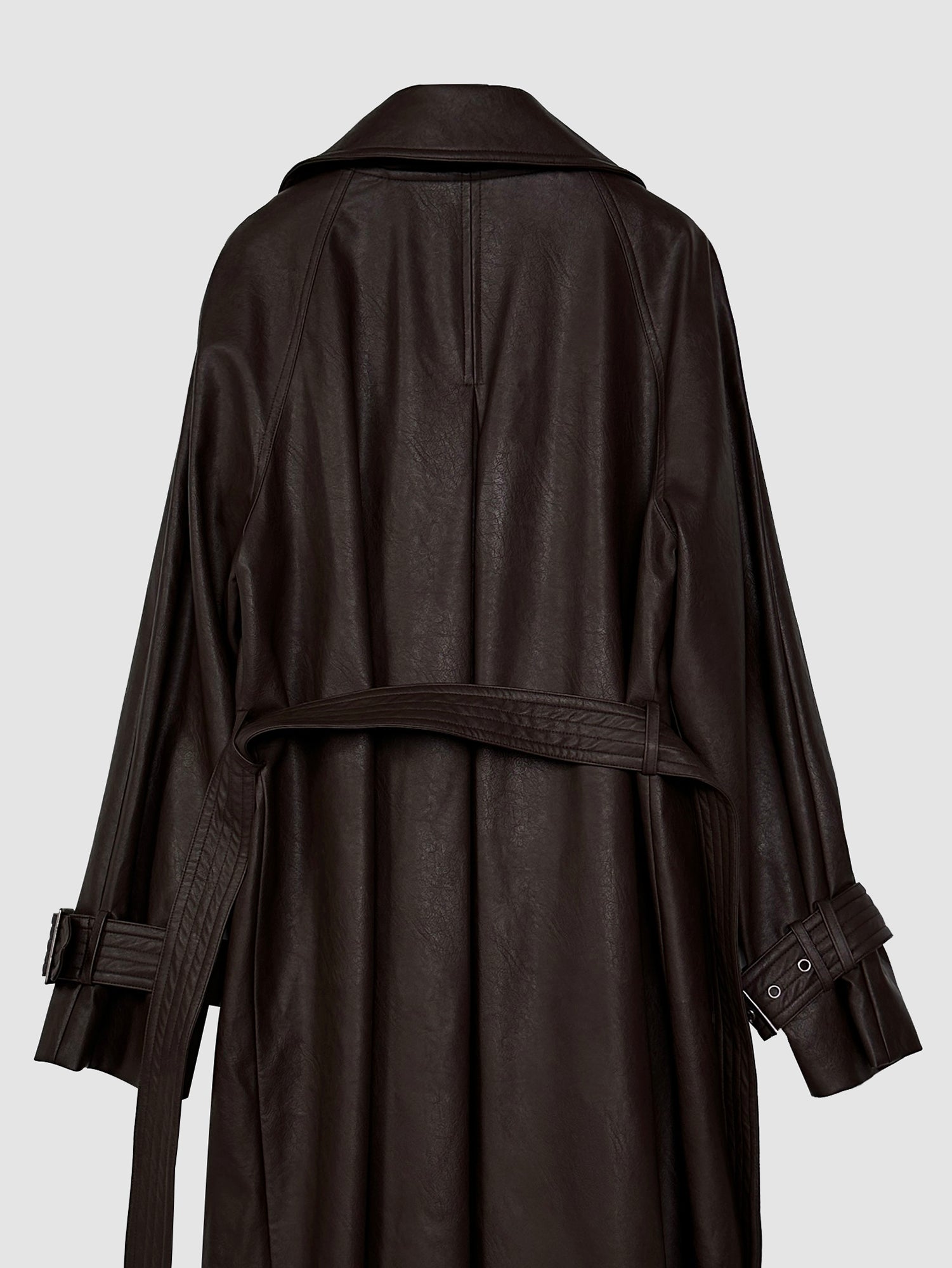 A close-up, detailed view of the back of the belted leather trench coat, highlighting its fitted design and showcasing the distinctive belt feature.