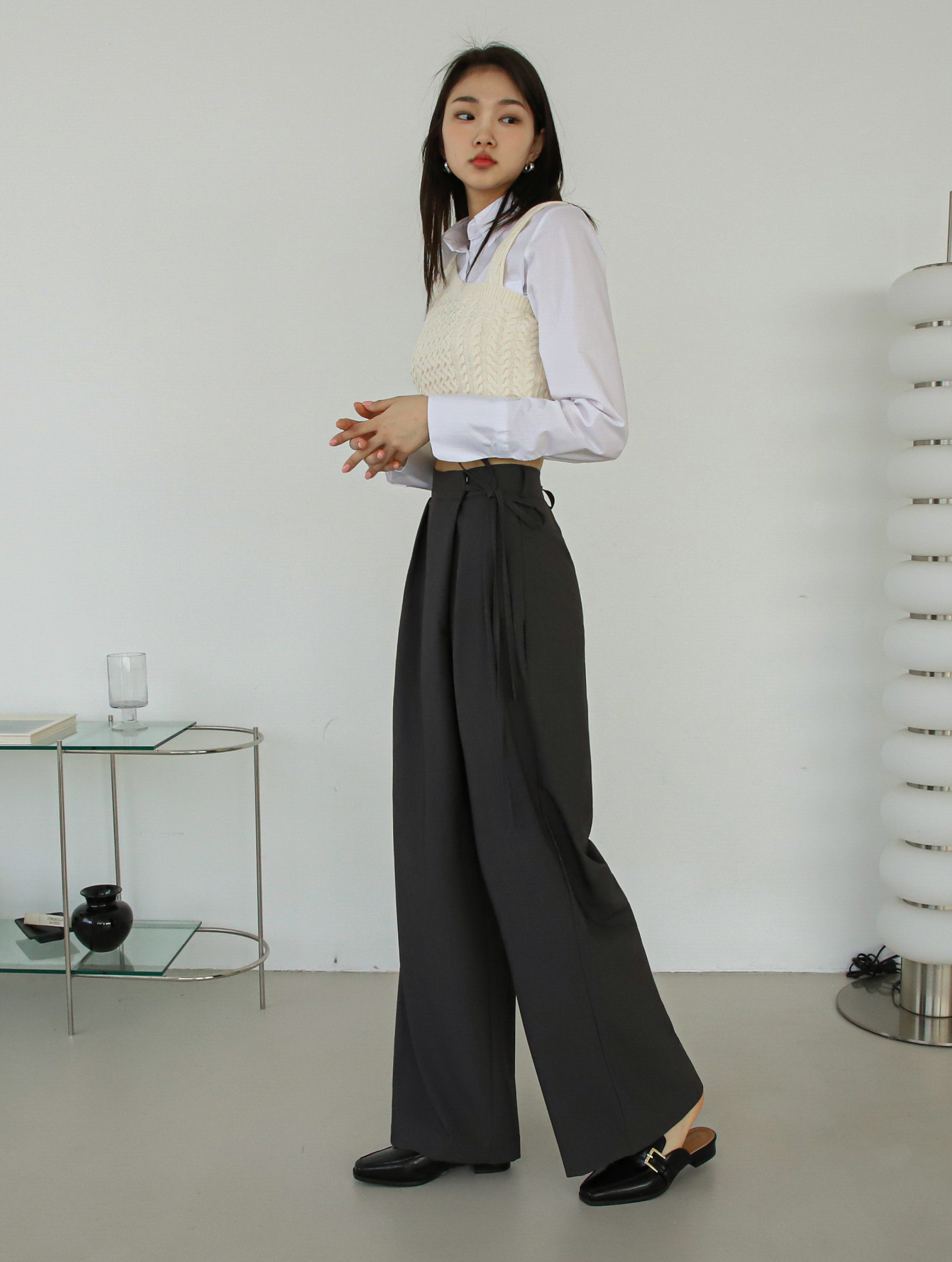 Left angle of a model wearing a belted tie pants showing the angle of a belted-tie.