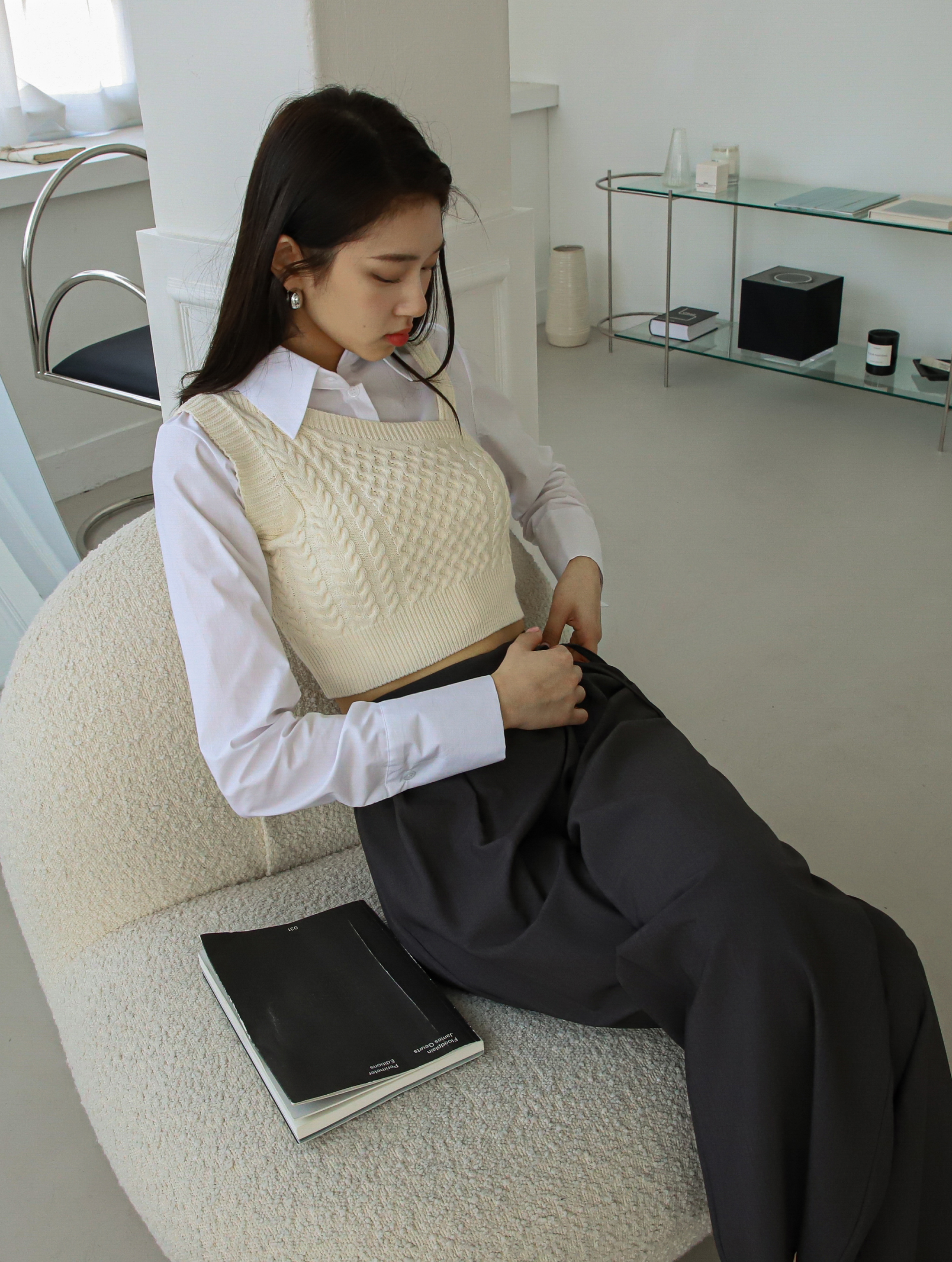 A model in a seated position wearing the belt tie pants.