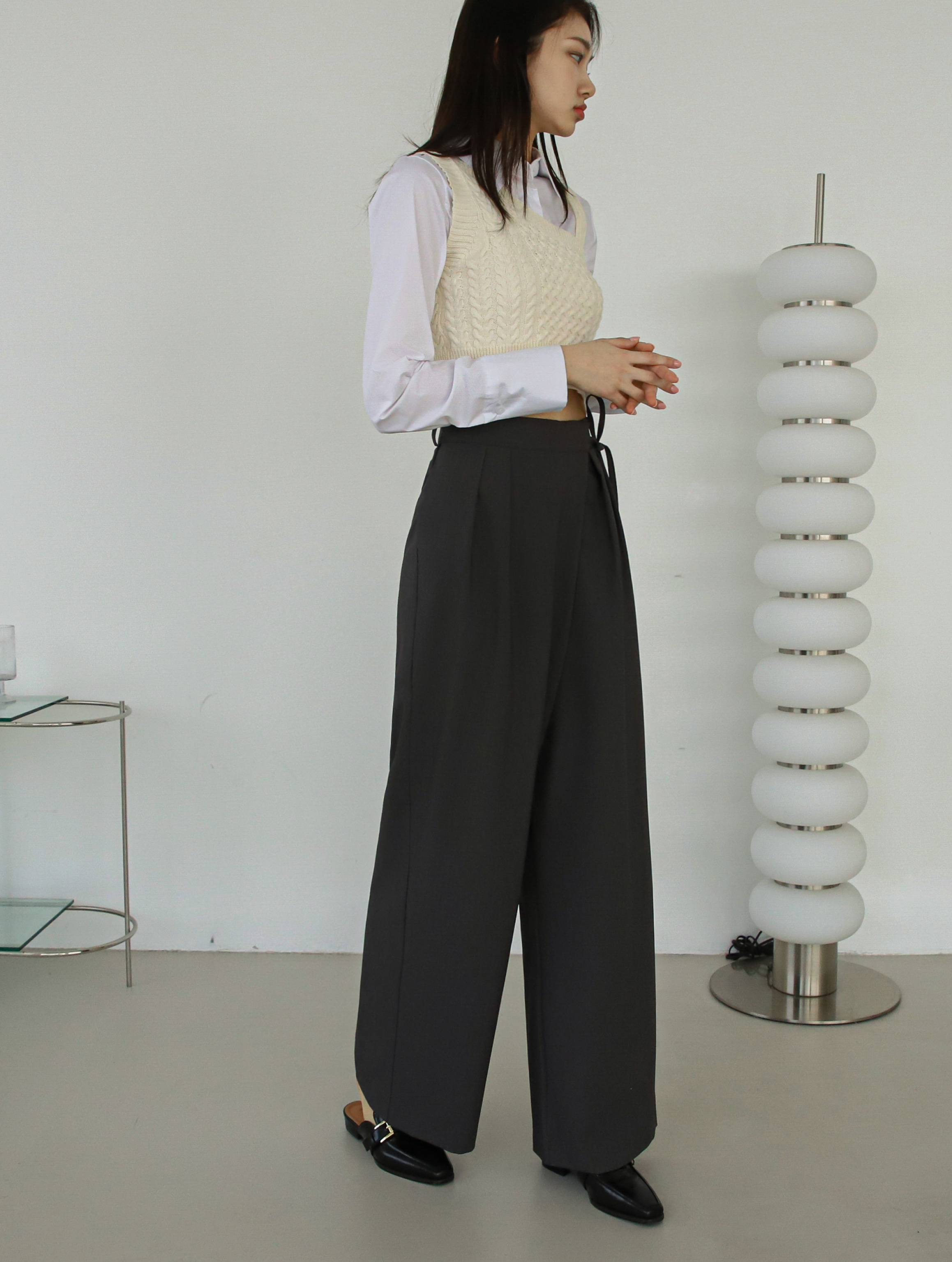 A side view angle of a model wearing a belted tie pants.