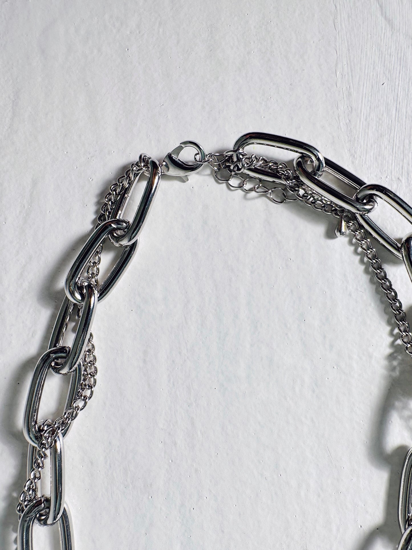 Zoomed in, a close-up of the Bold Chain Necklace reveals intricate details of its clasps and chains.