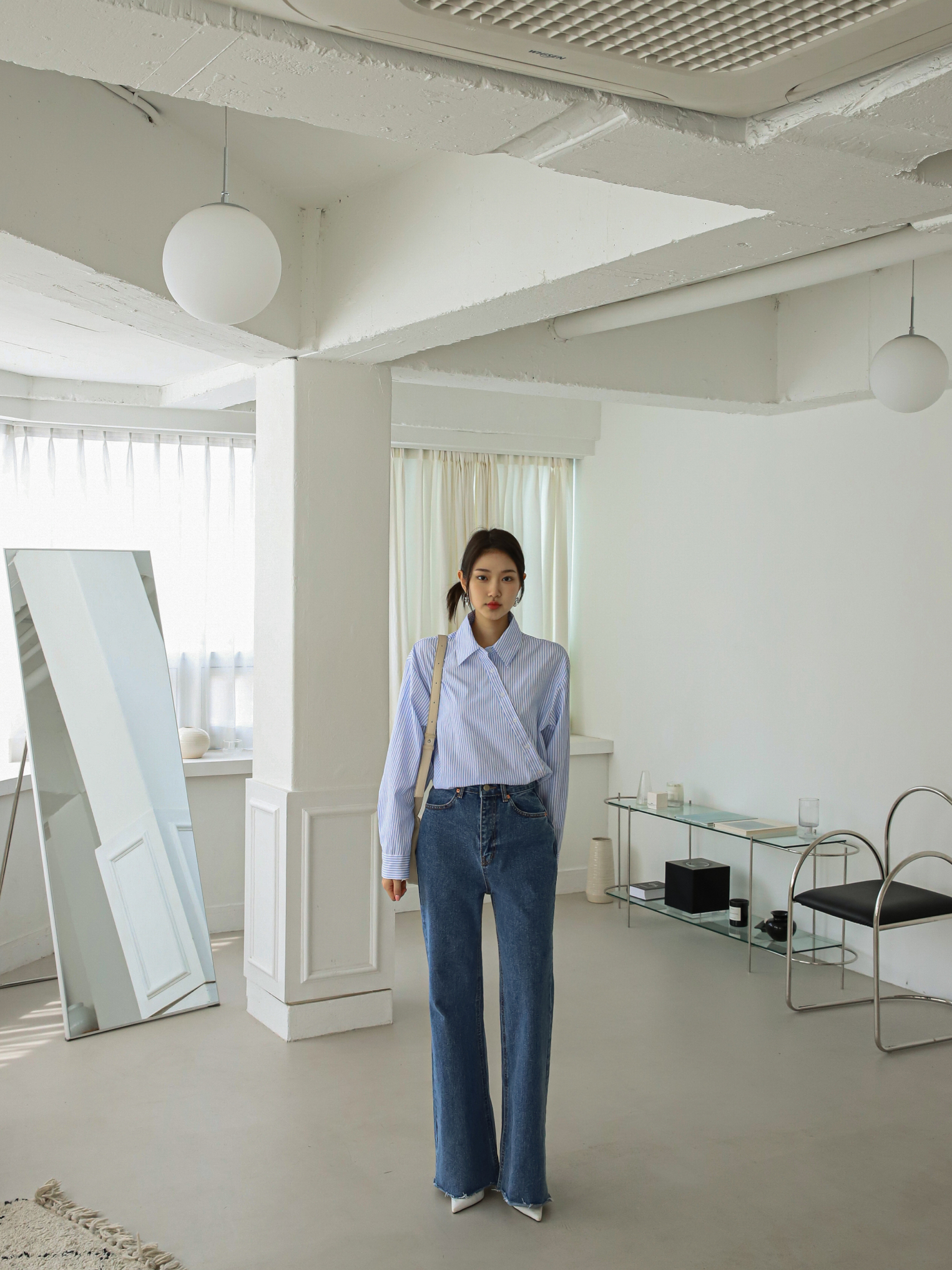 A long shot of the model wearing the bootcut jeans, showcasing the jeans' length and fit.