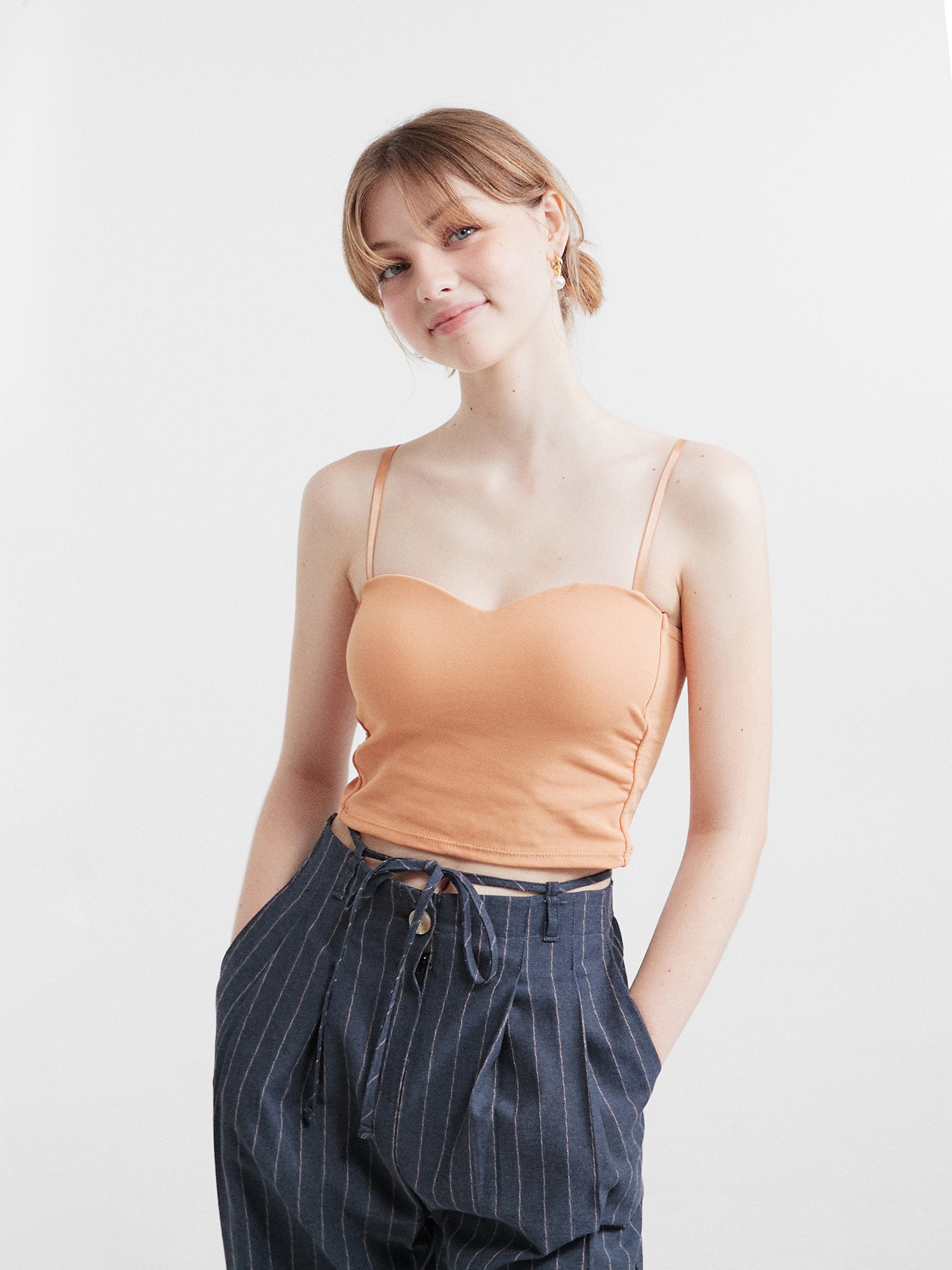 Front view of the model exuding Korean street fashion flair while confidently rocking a chic bustier crop top, making a bold fashion statement.