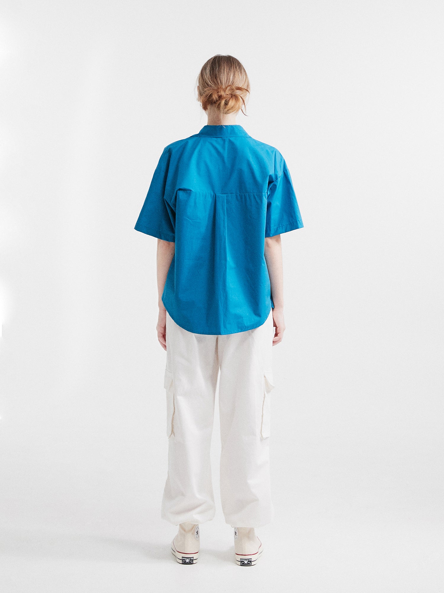 Back view of a model wearing the blue button front shirt.