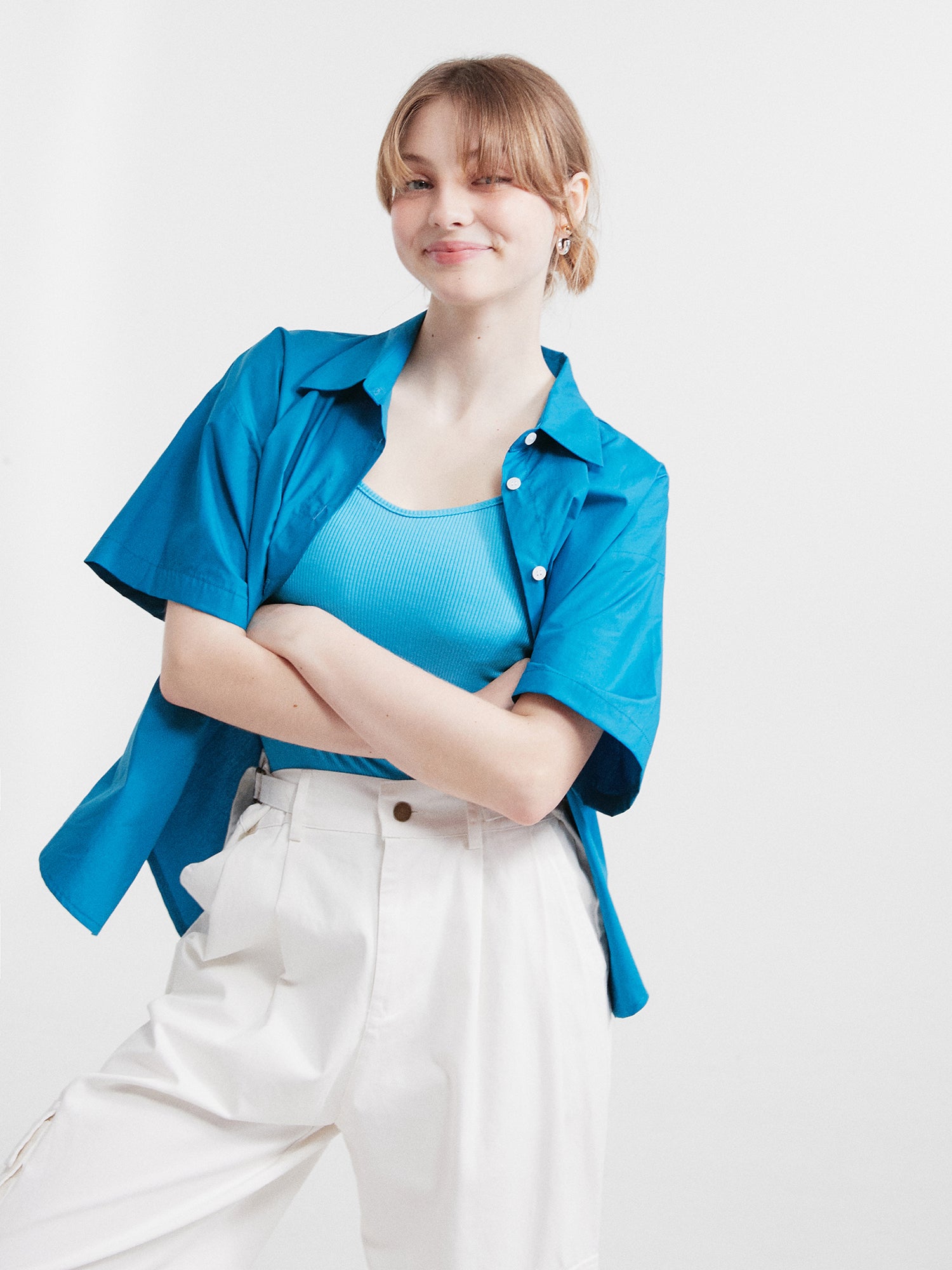 Front view of the model with her arms crossed wearing the blue Button Front Shirt.