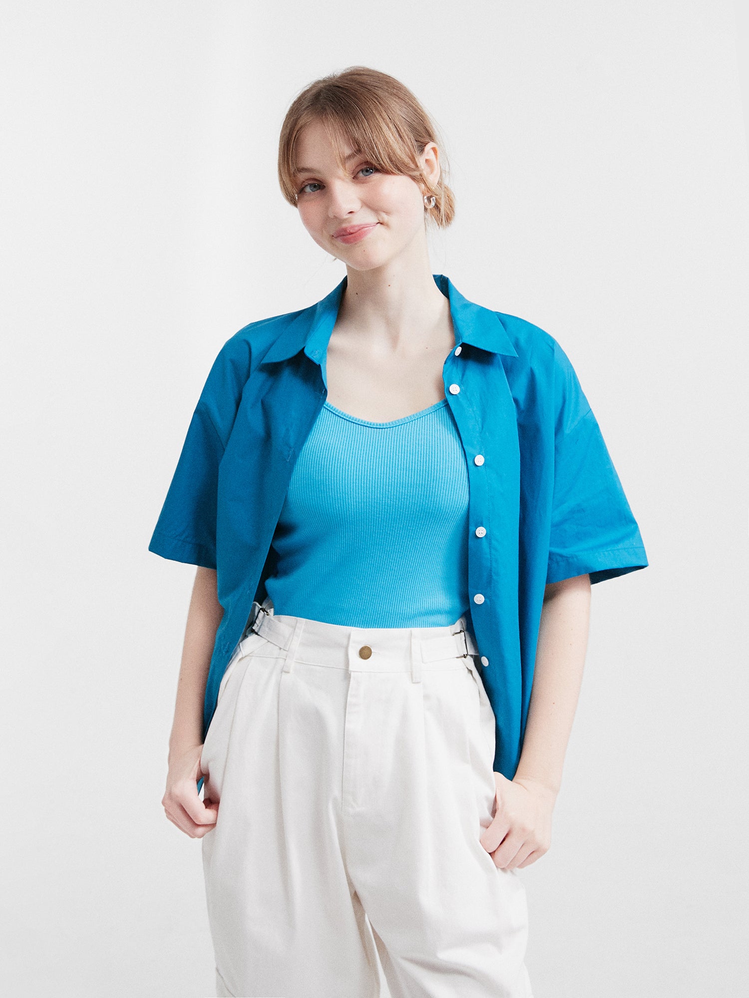 A model shot facing the front wearing the blue button front shirt.