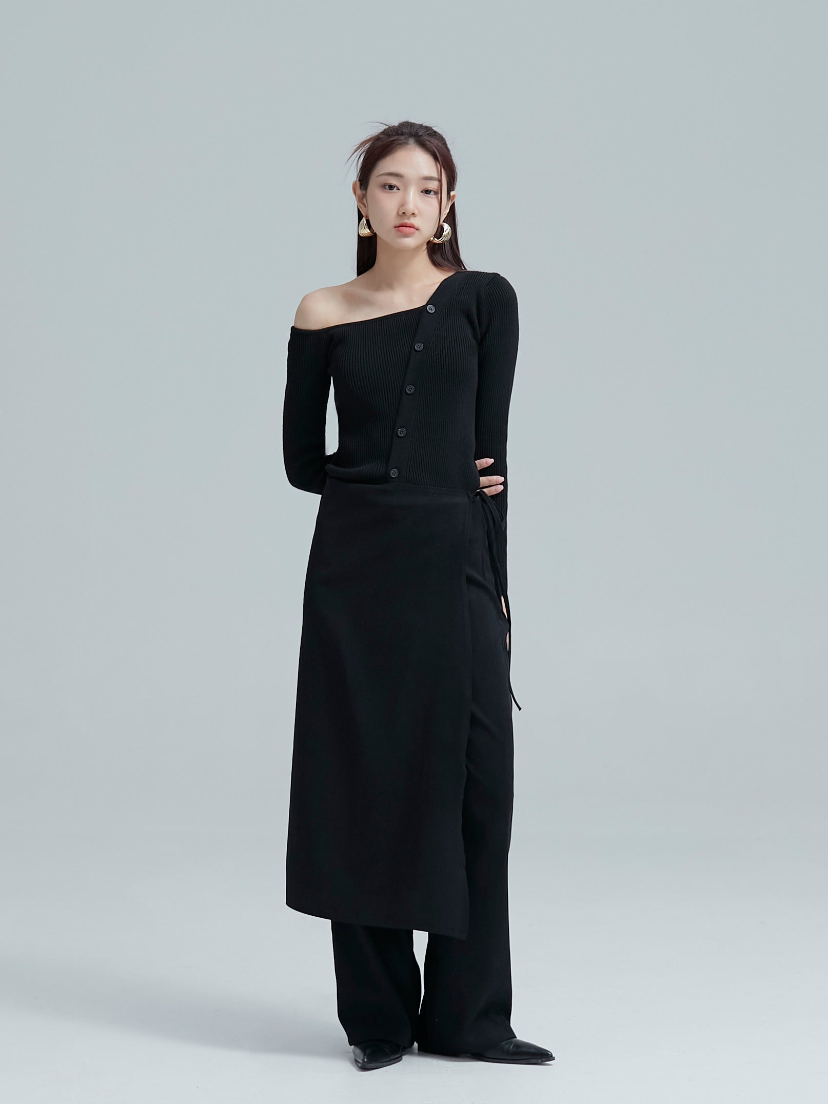 Full shot of the model wearing the black button off shoulder to showcase its delicate fitting of the korean street fashion.