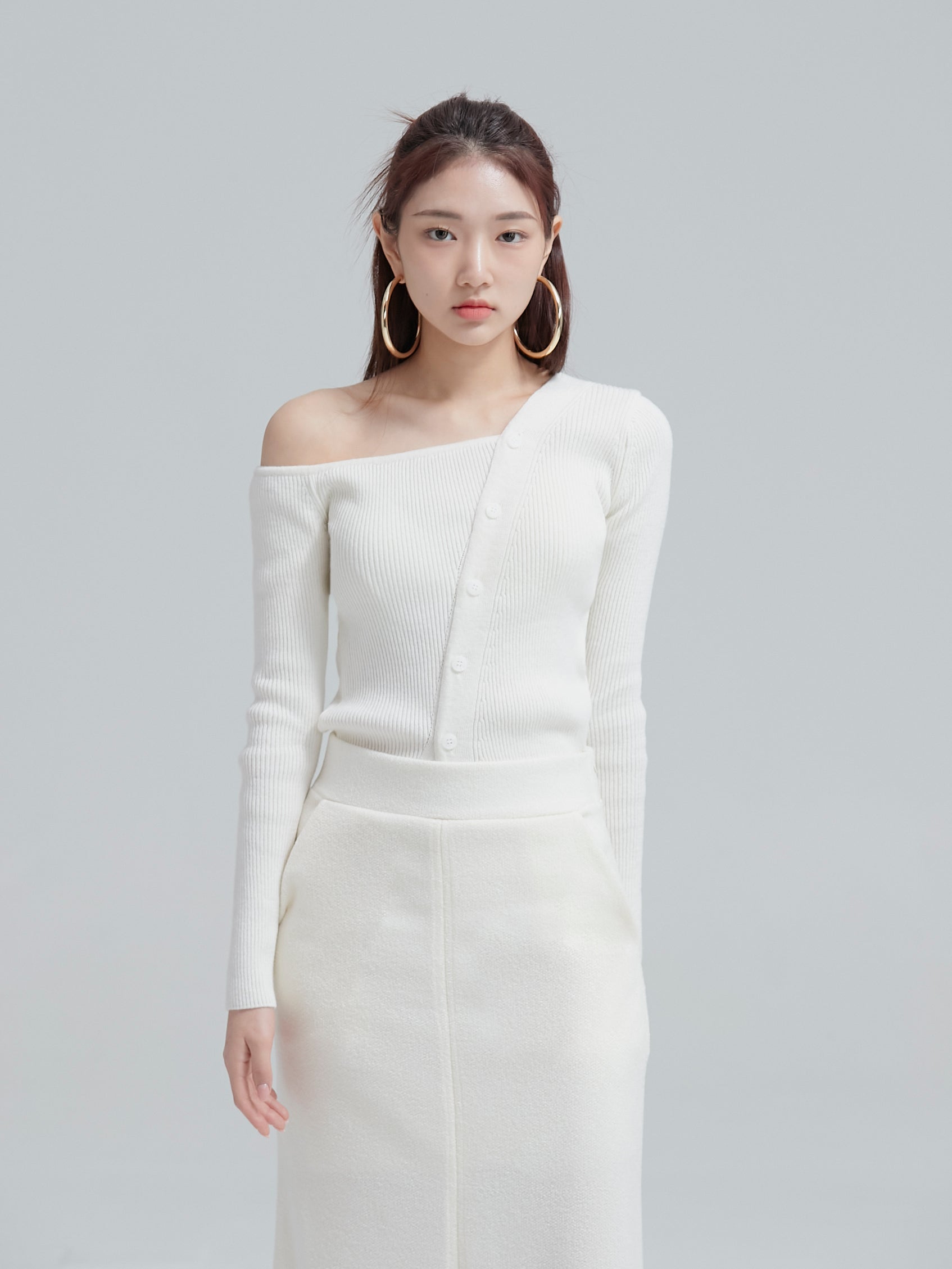 Front view of the model wearing the white button off shoulder top to showcase its front design of the top.