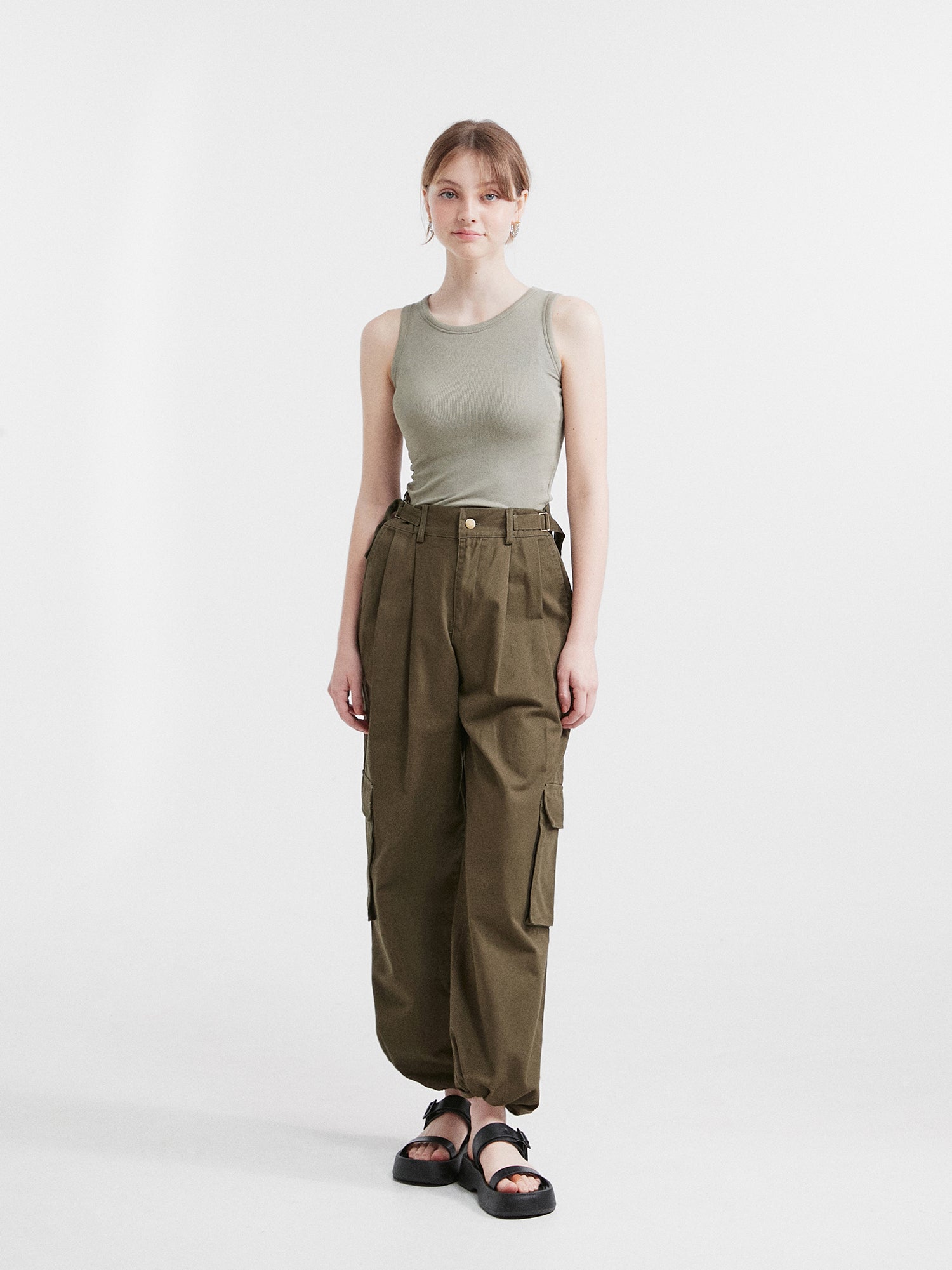 A full-shot of the model wearing the cargo pants matching it with sleeveless tank top.