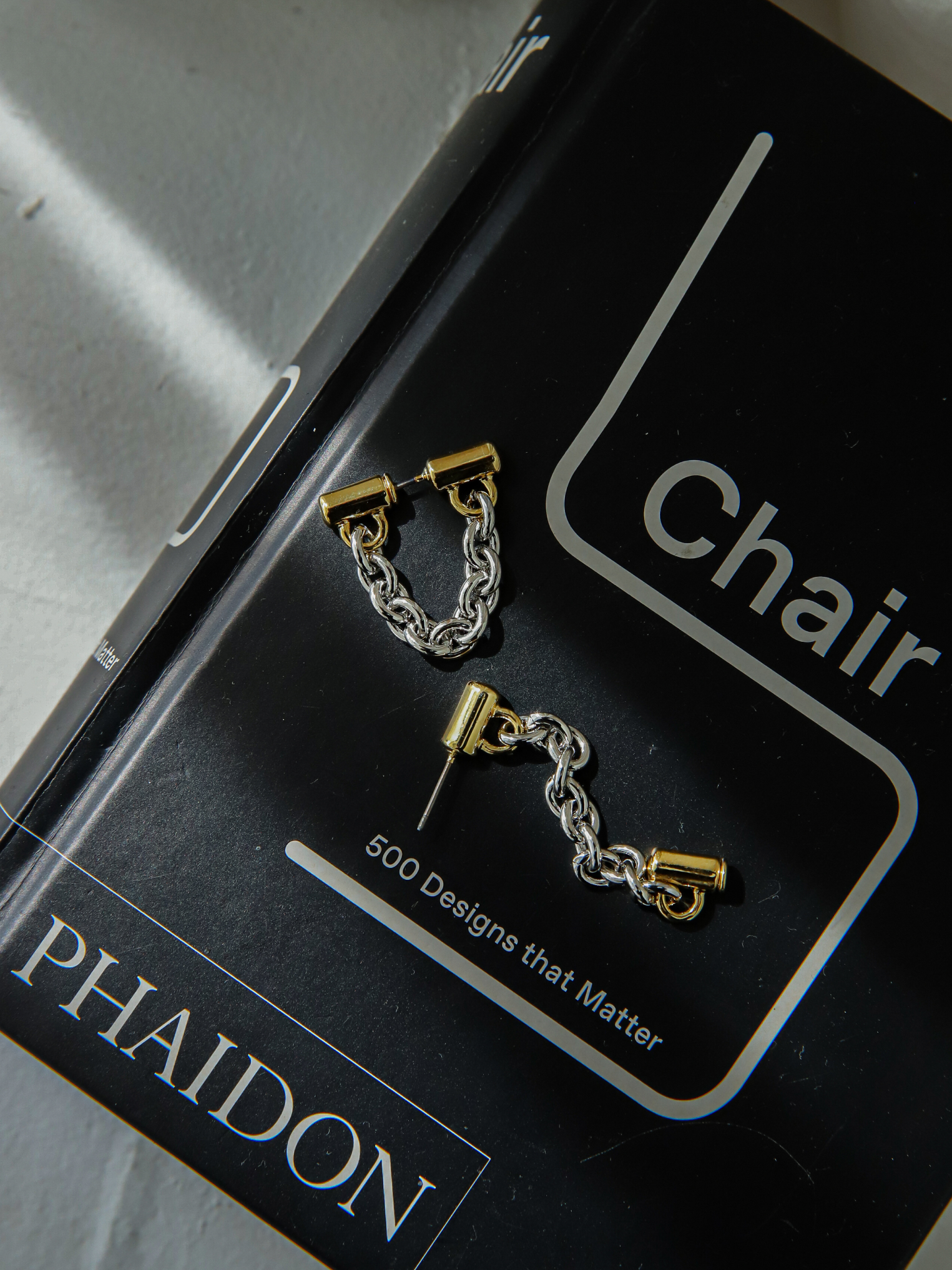 A pair of chain earrings inspired by korean street fashion showcased atop a book.