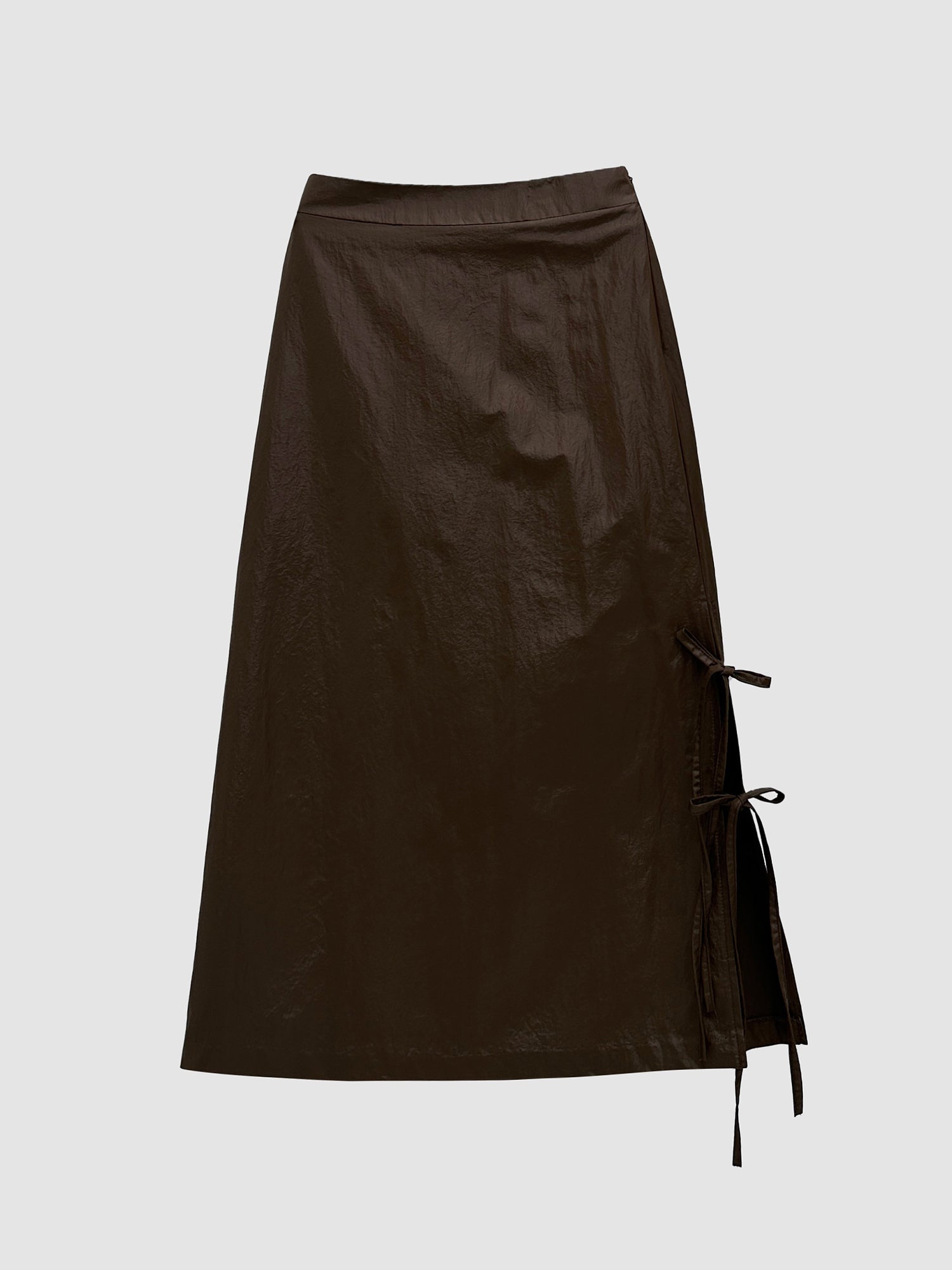 Provide an in-depth look at the brown coated midi skirt, highlighting its intricate front-side details.