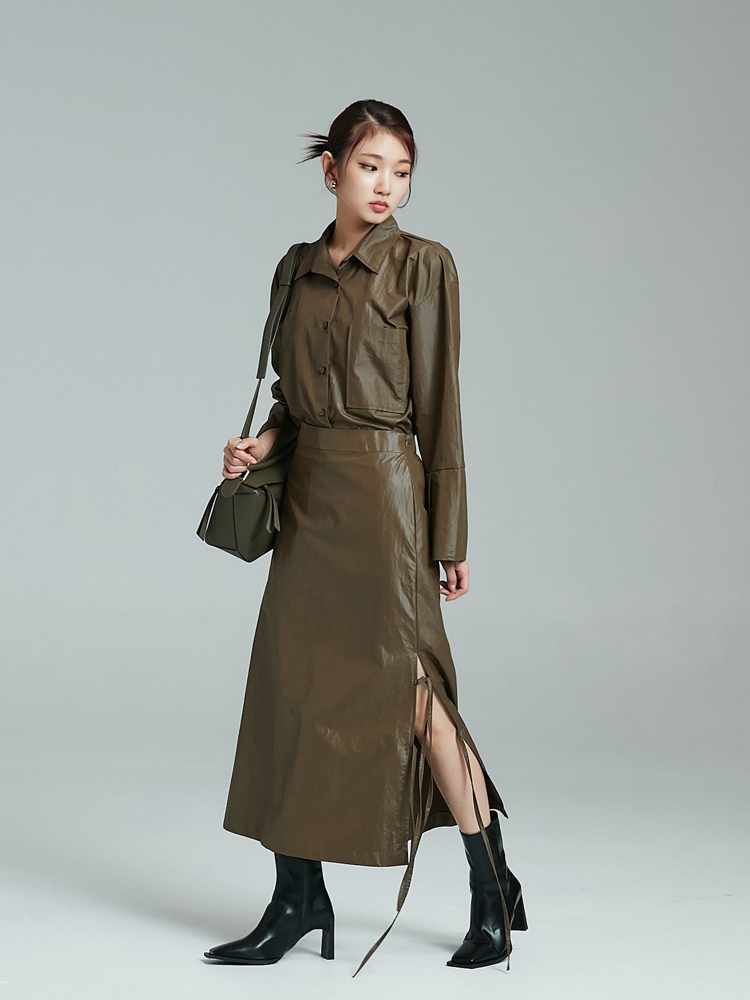 Side look of the model wearing the coated midi skirt showcasing its korean street fashion vibe.