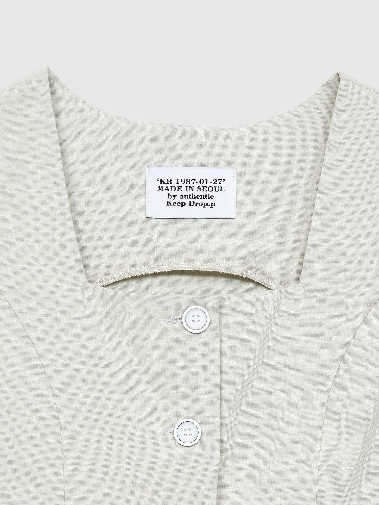 A closeup shot of the cropped blazer highlighting the front buttons and neck design.