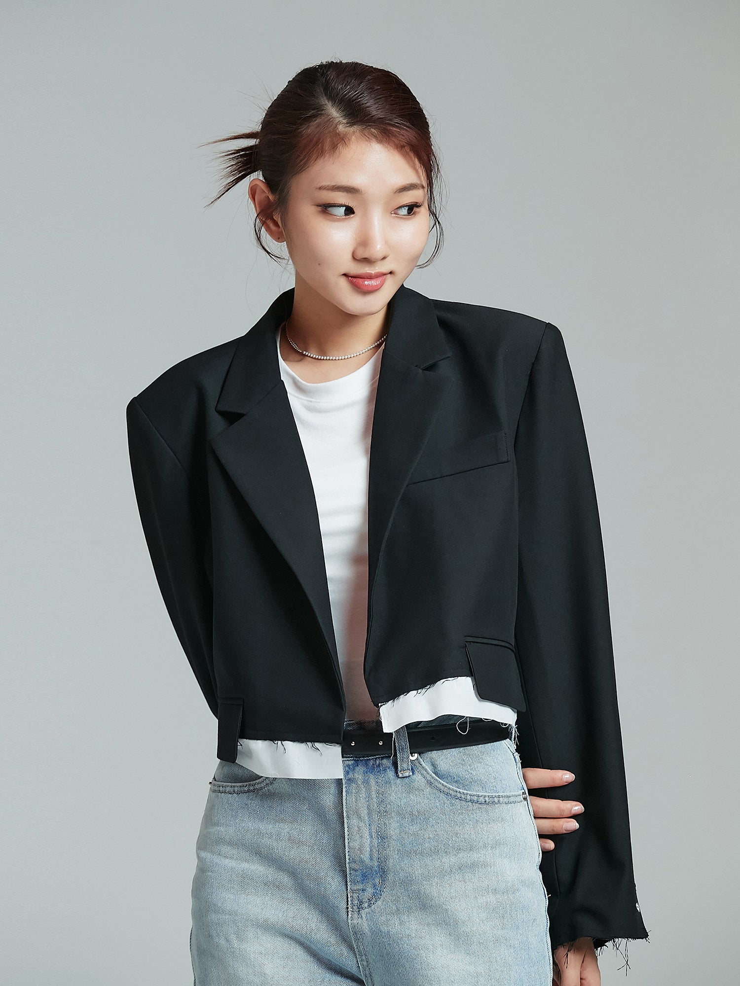 A frontal perspective of the model donning the black cropped layered blazer, highlighting its distinct Korean street fashion vibe.