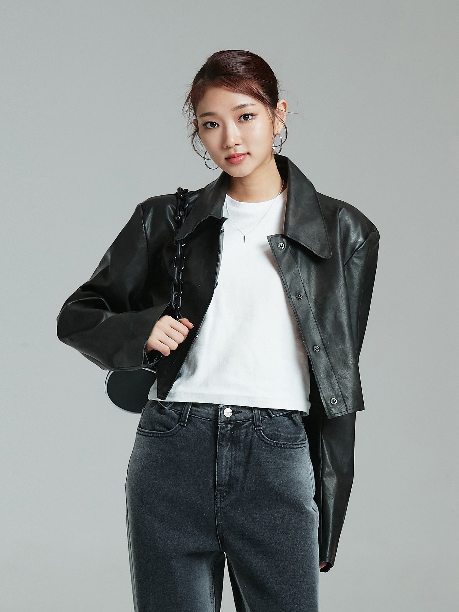 Front shot of the model wearing the black cropped leather jacket showcasing the korean street fashion vibe.