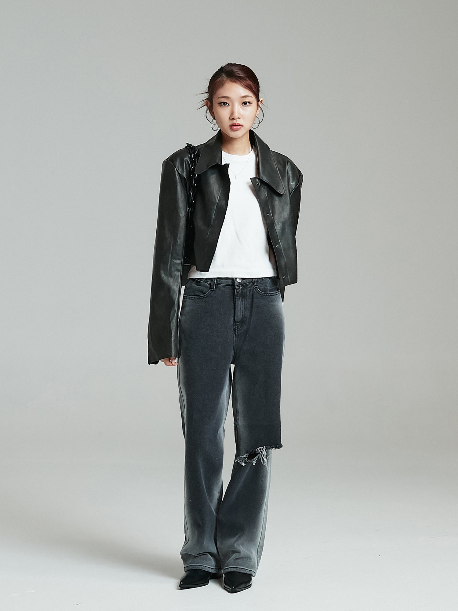 Full-shot of the model wearing the cropped leather jacket showcasing the korean street fashion look.