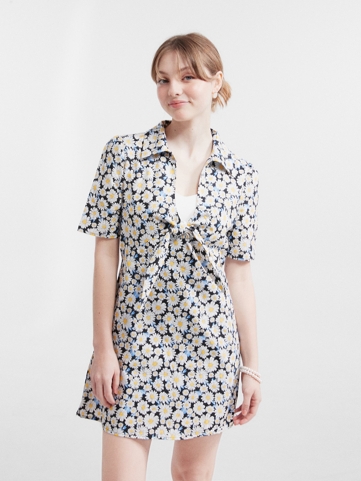 A front view of the model wearing the daisy mini dress showing the delicate daisy prints of the dress.