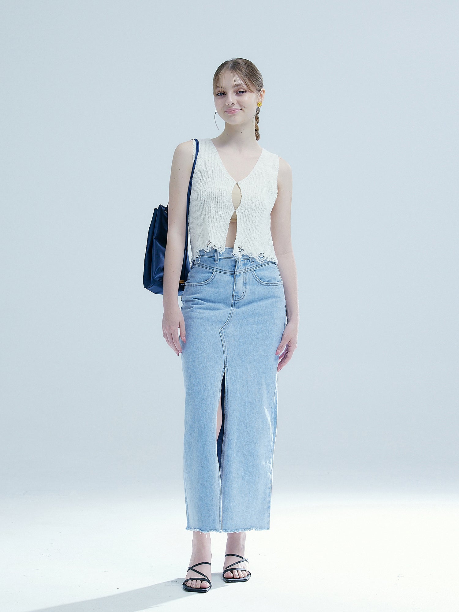 Full-shot of the model wearing the denim slit midi skirt.