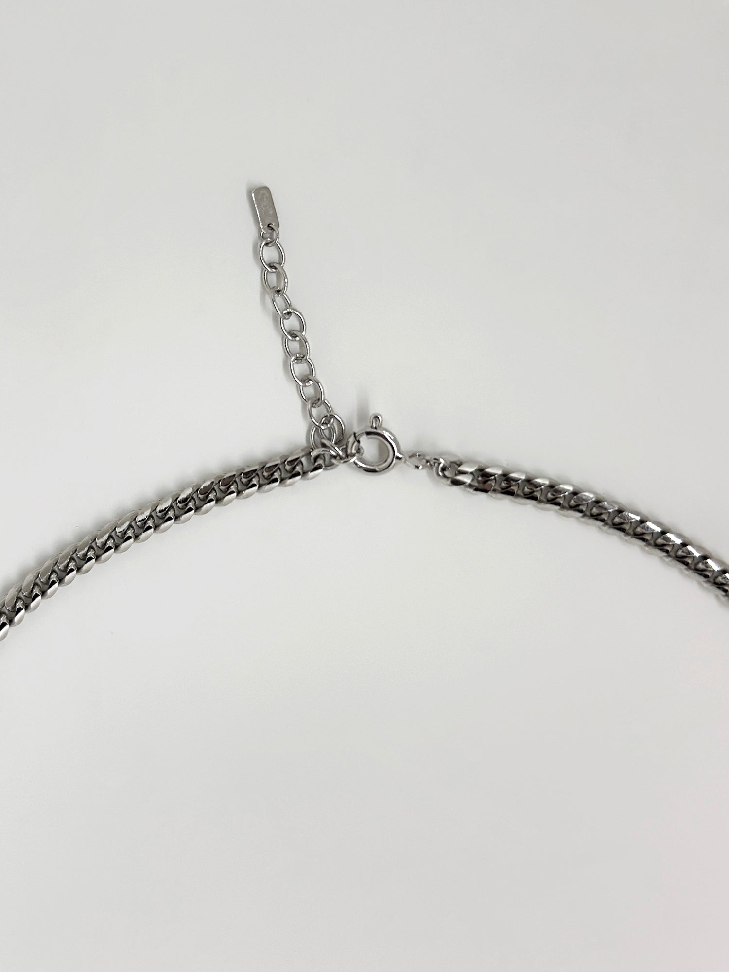 A close-up view of the diamond beaded necklace showing its clasps and metal details.