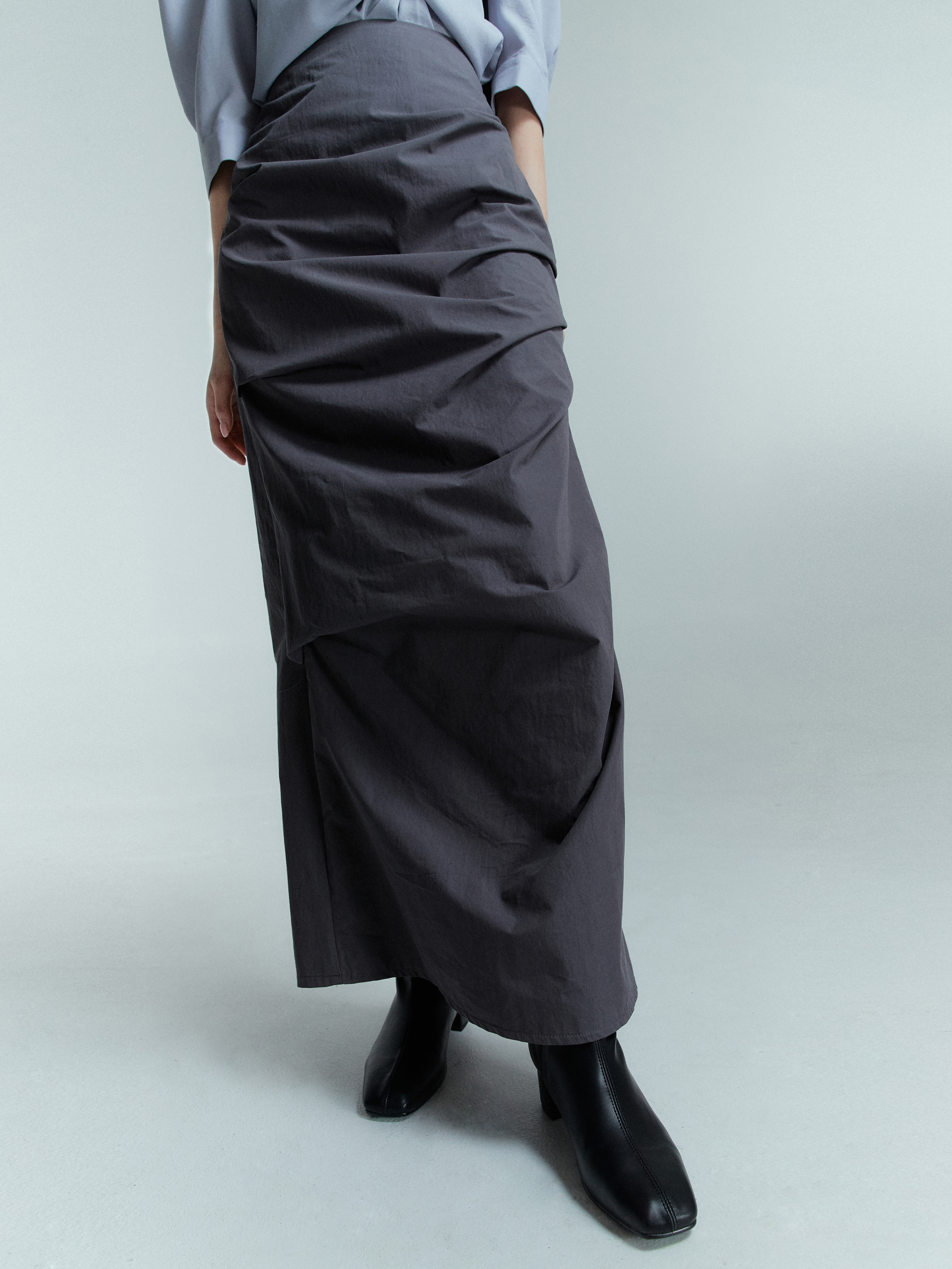 This close-up view of a maxi draped skirt shows the details of its draped design.