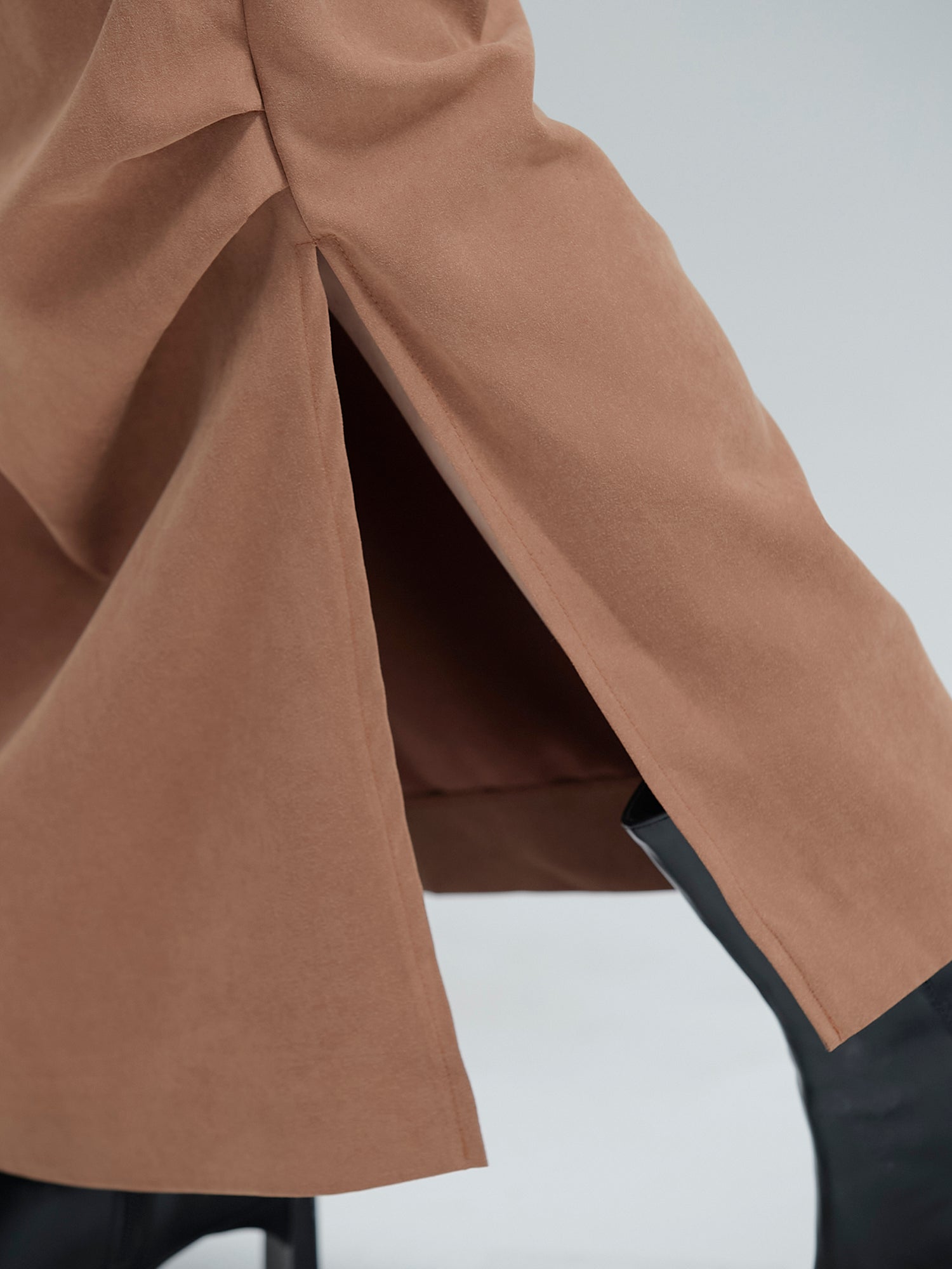 Zoomed-in shot of the slit cut detail of the fall draped skirt.