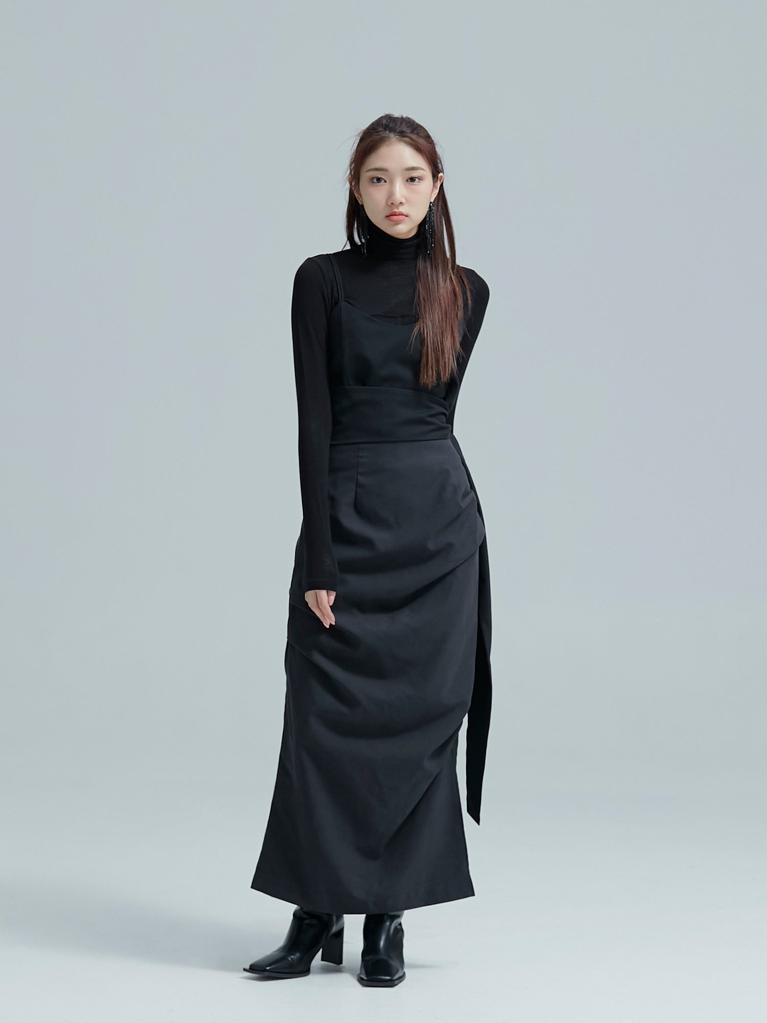 Front shot of the model wearing the black fall draped skirt accentuating its chic vibe of the Korean street fashion.