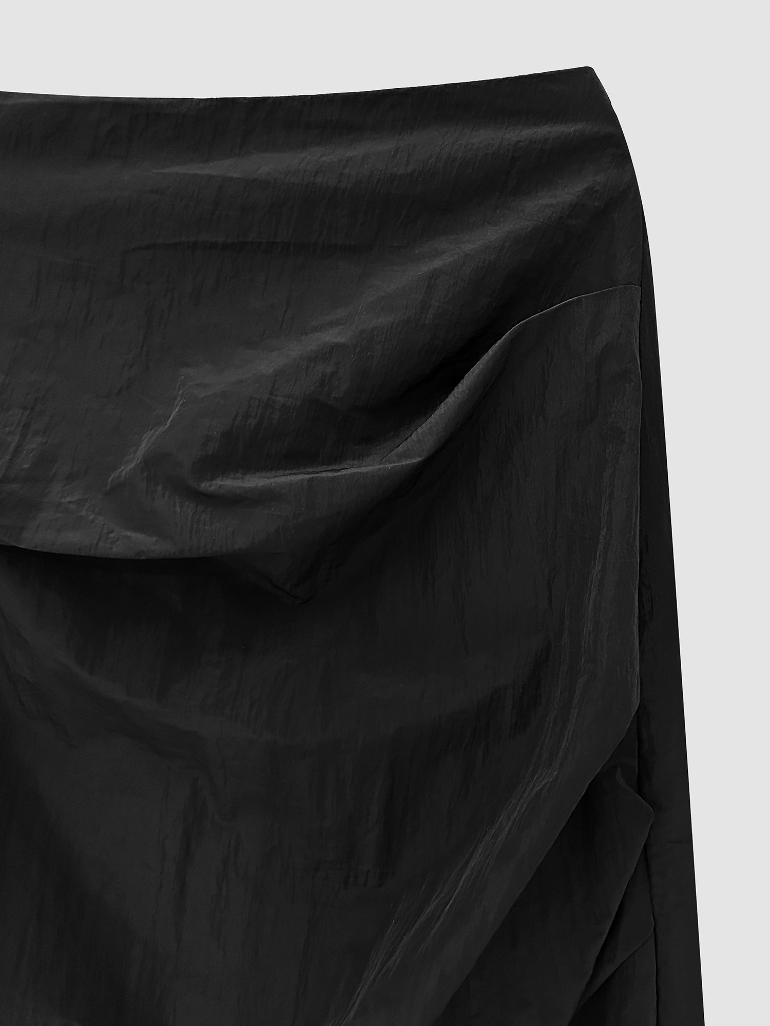 A close-up capture of the fall draped skirt, highlighting both the texture of the fabric material and the graceful draping of the skirt's design.