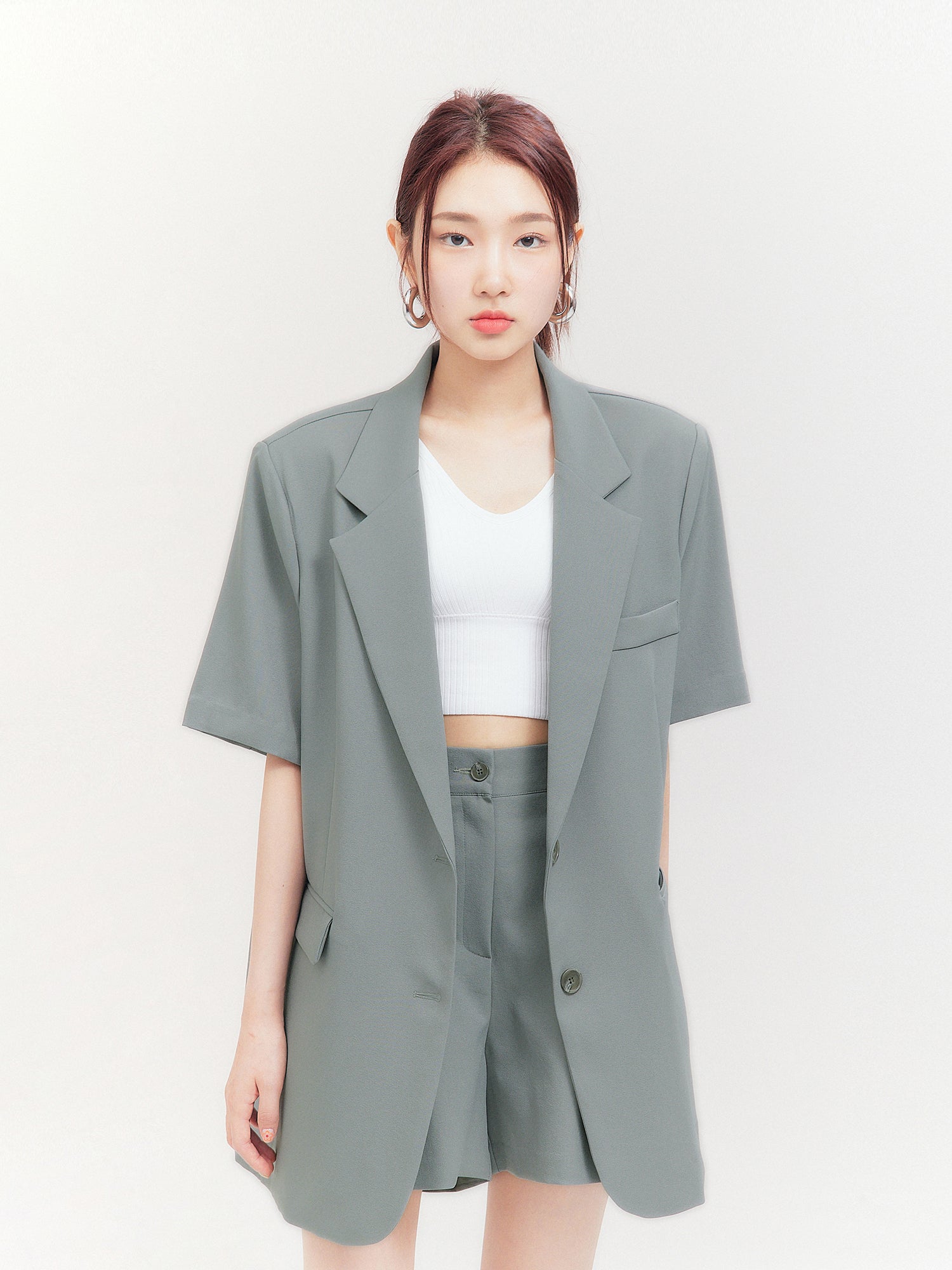 A front view of the model looking sideways, exuding Korean street fashion vibes while wearing the flap pocket blazer.