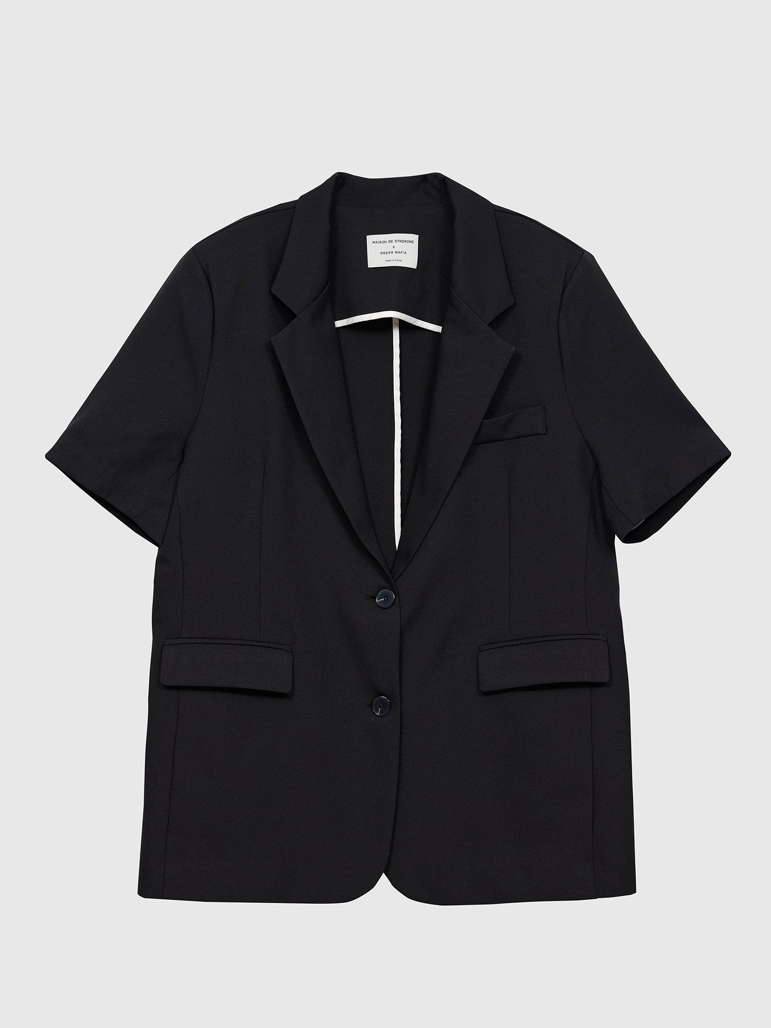 The black flap pocket blazer from the front, set against a gray backdrop, accentuating its suitability for Korean aesthetic outfits with its timeless and fashionable appeal.