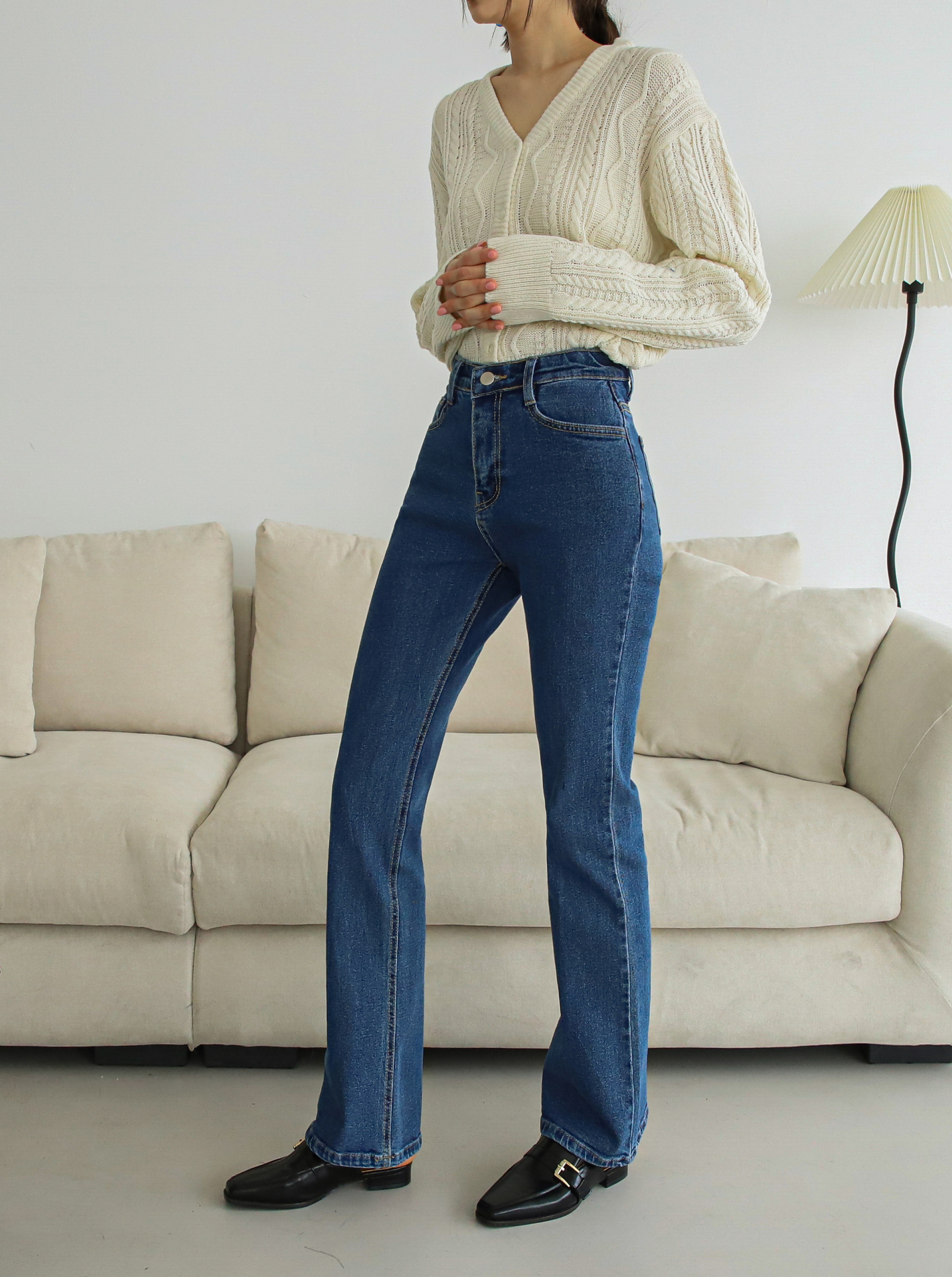 Model's side view showcasing the design of side of the flare jeans.