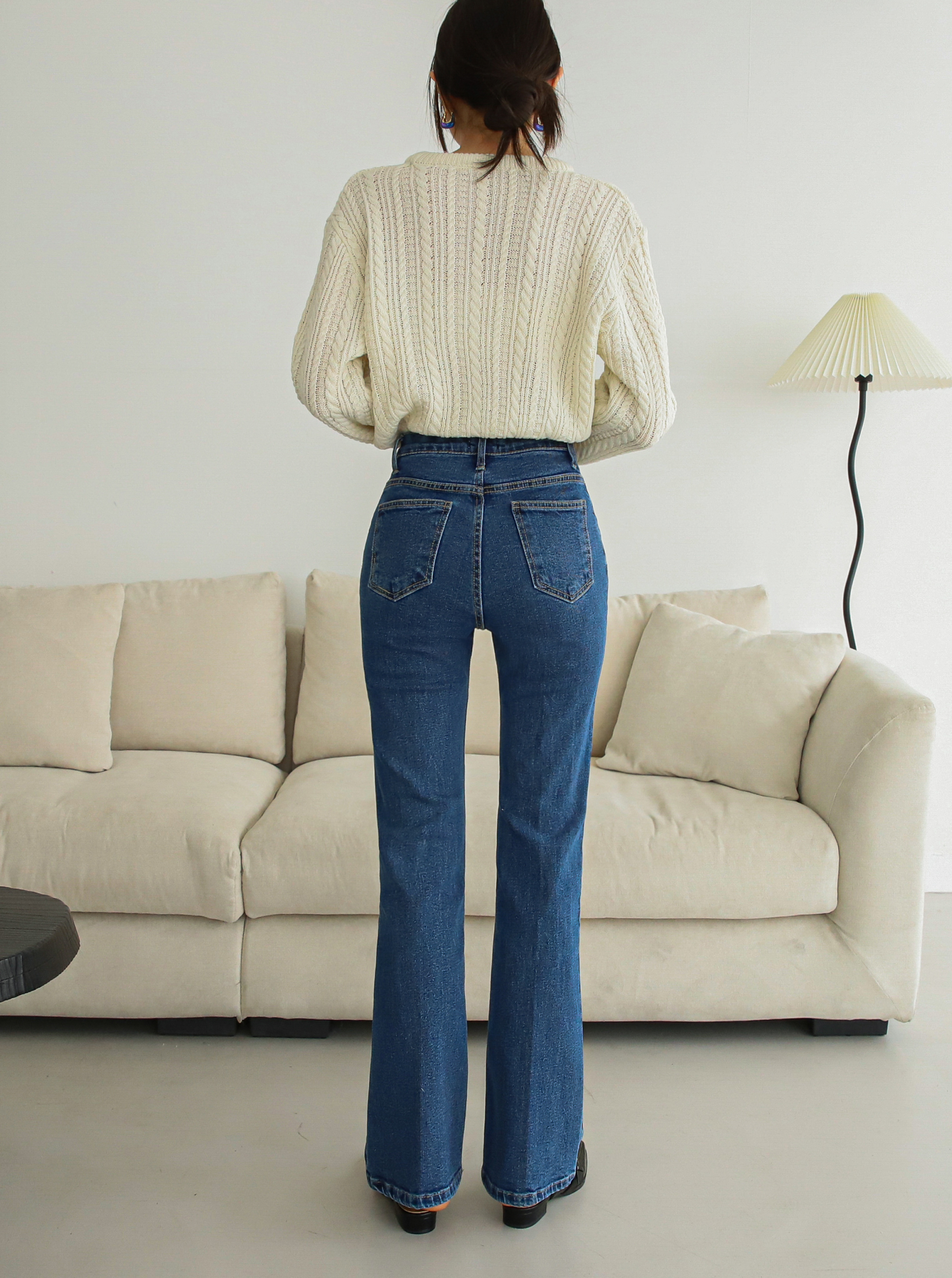 A model shows off the flattering fit of the flare jeans from behind.