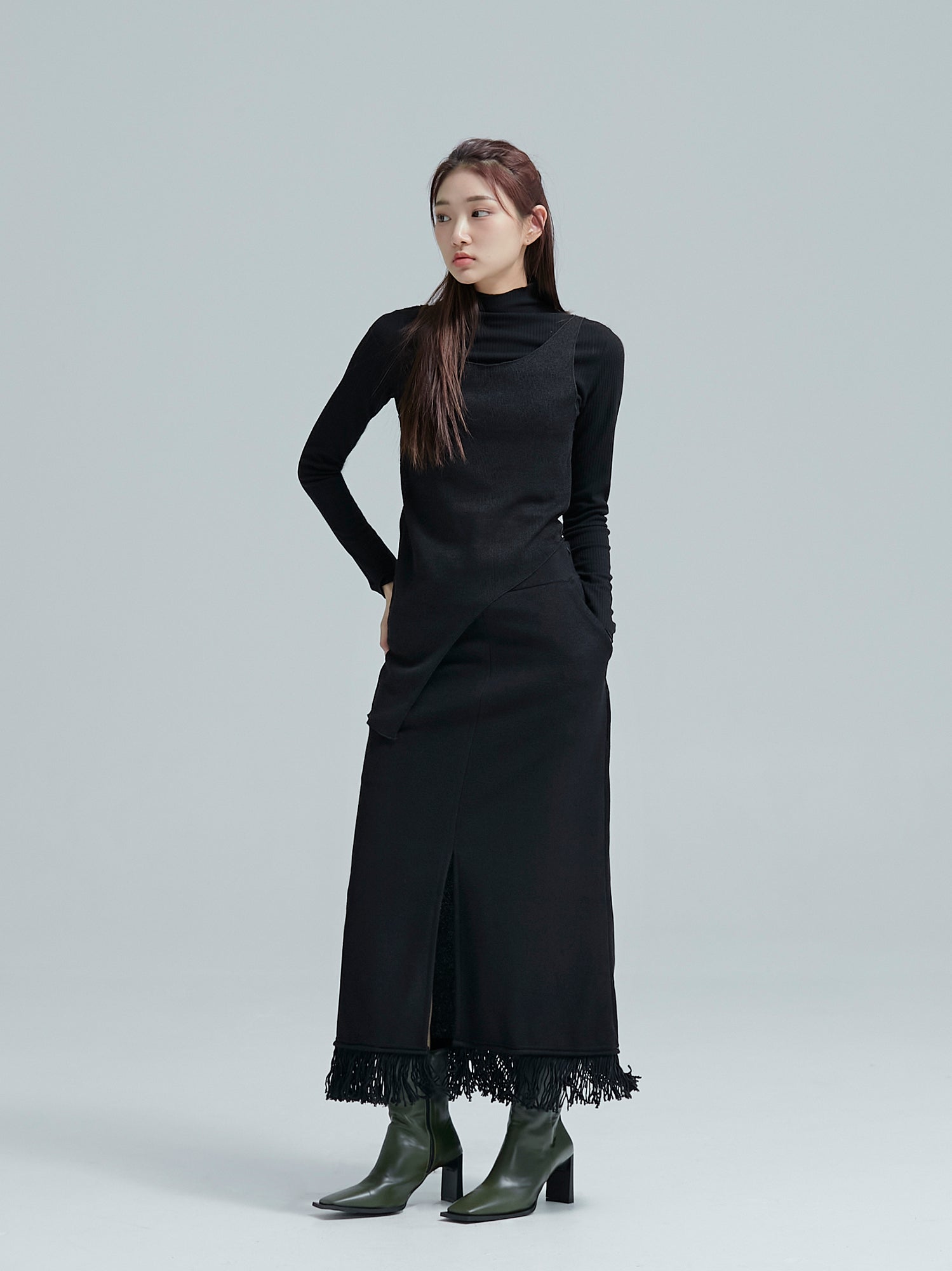 Model glancing to the side wearing the black fringe split maxi skirt accentuating its Korean street style.