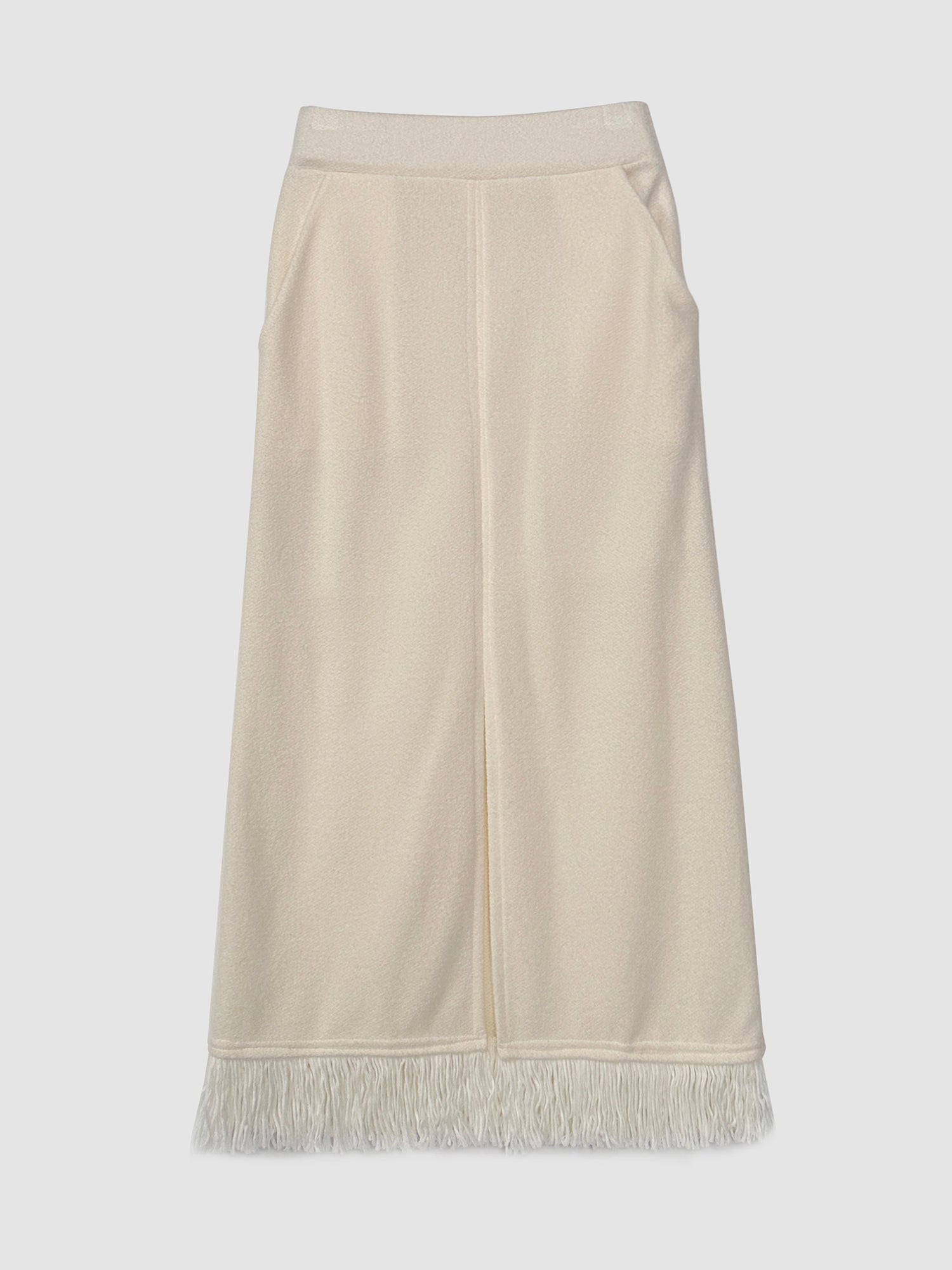 A detailed product view of the fringe split maxi skirt, emphasizing the tassels on the bottom and pockets that epitomize the pinnacle of Korean street style.