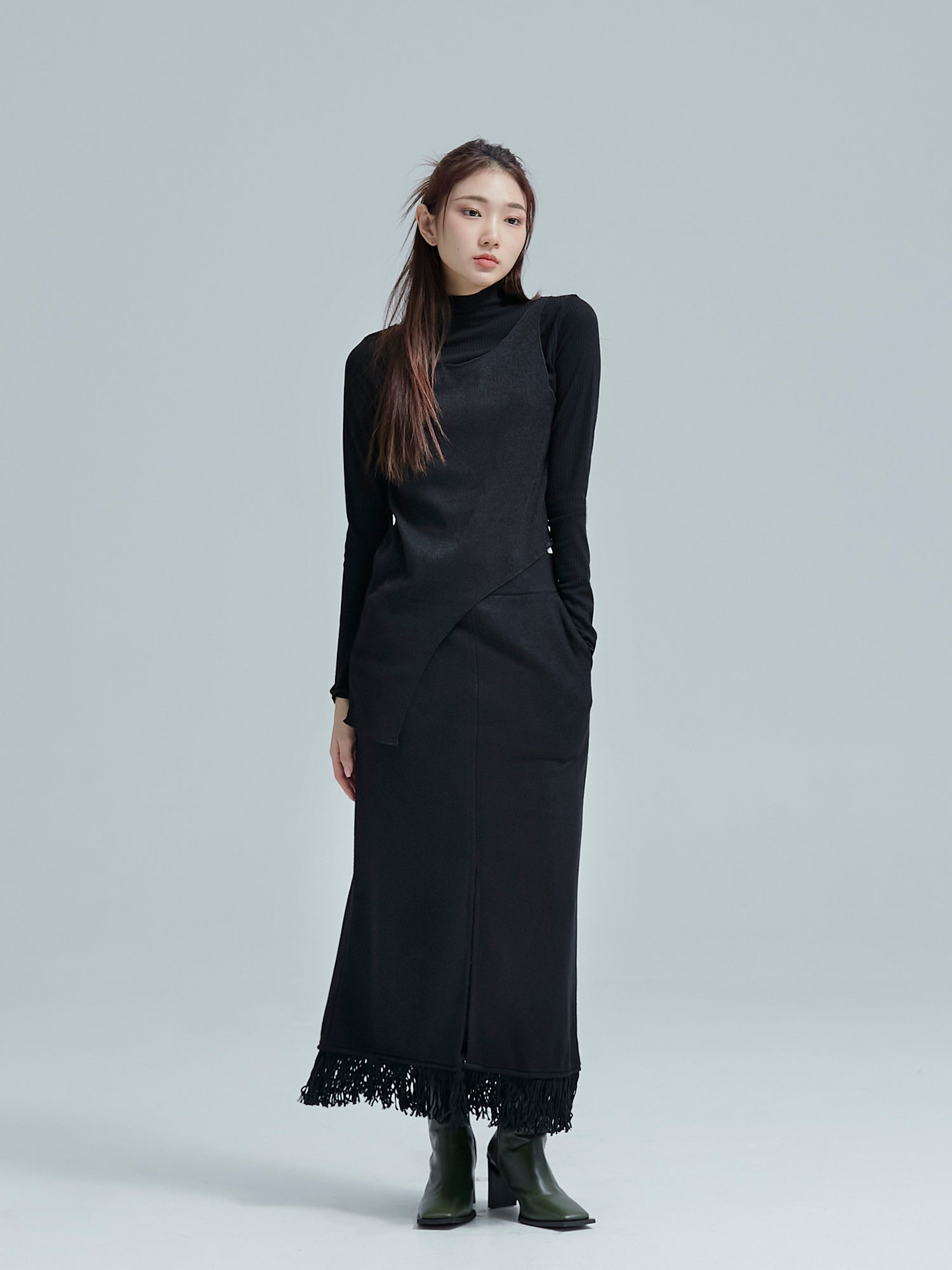 The model is standing while wearing the fringe split maxi skirt to show its full lengths of the skirt.