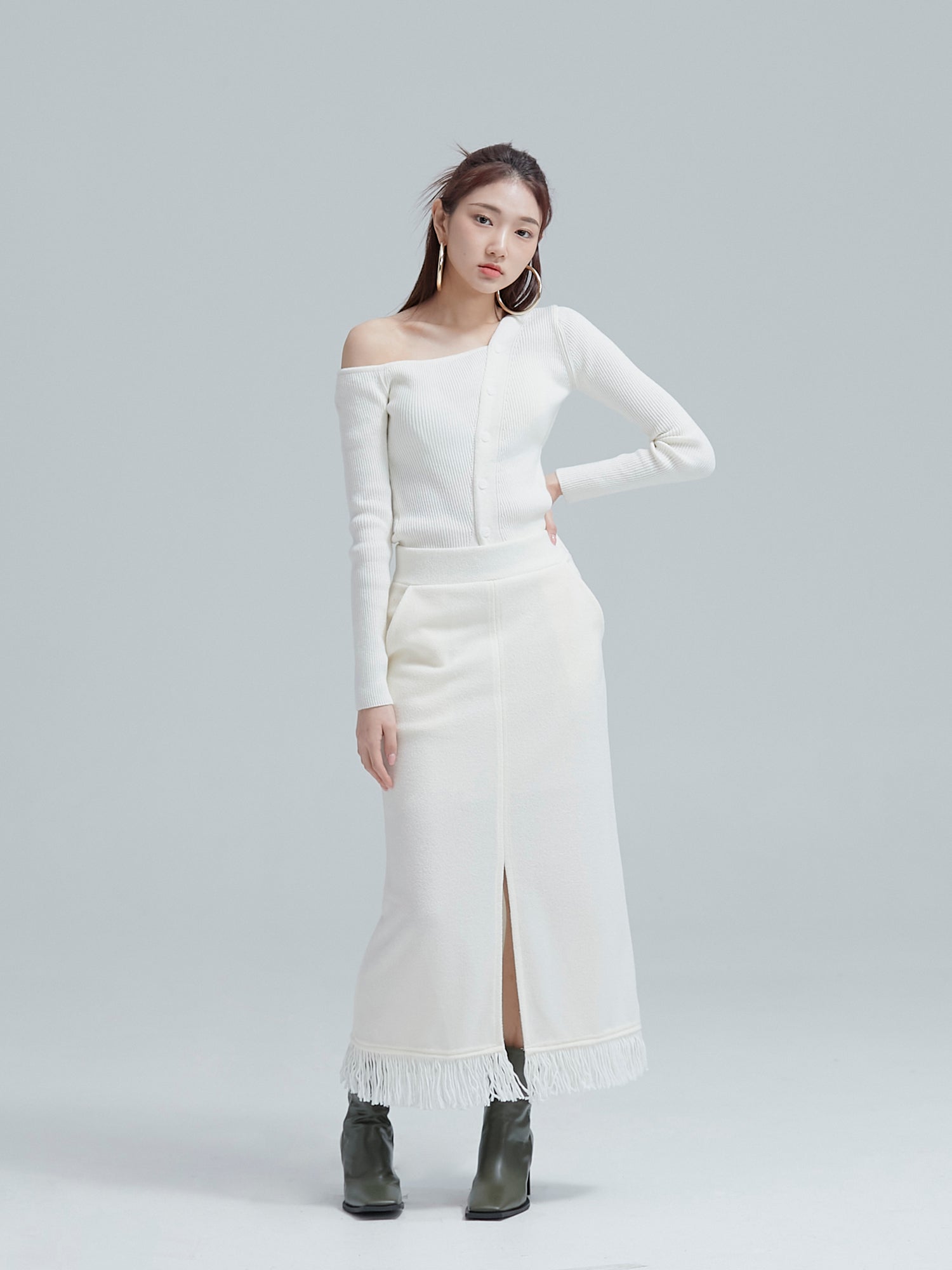 Model is posing while wearing the white fringe split maxi skirt to showcase its split design of the skirt.