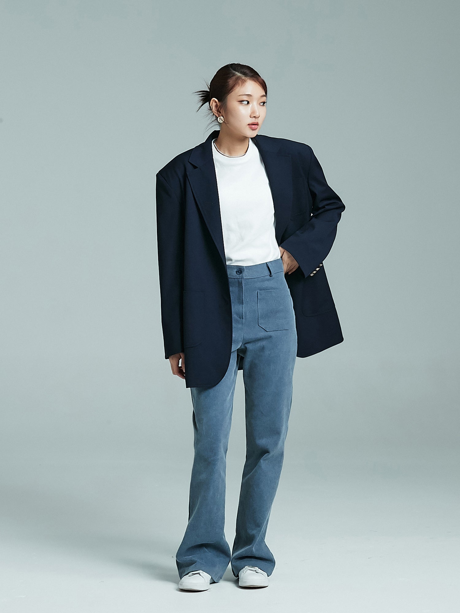 Front view of the model wearing the front pockets jeans matched with navy oversized blazer to showcase the korean aesthetic outfits.