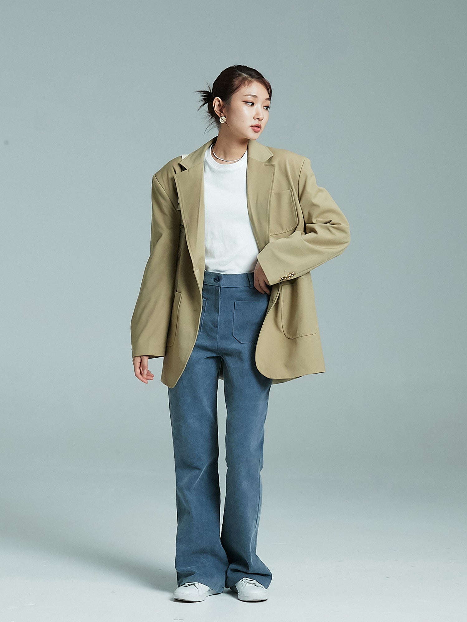 Front view of the model wearing the front pockets jeans matched with oversized pockets blazer to give off the korean aesthetic vibe.