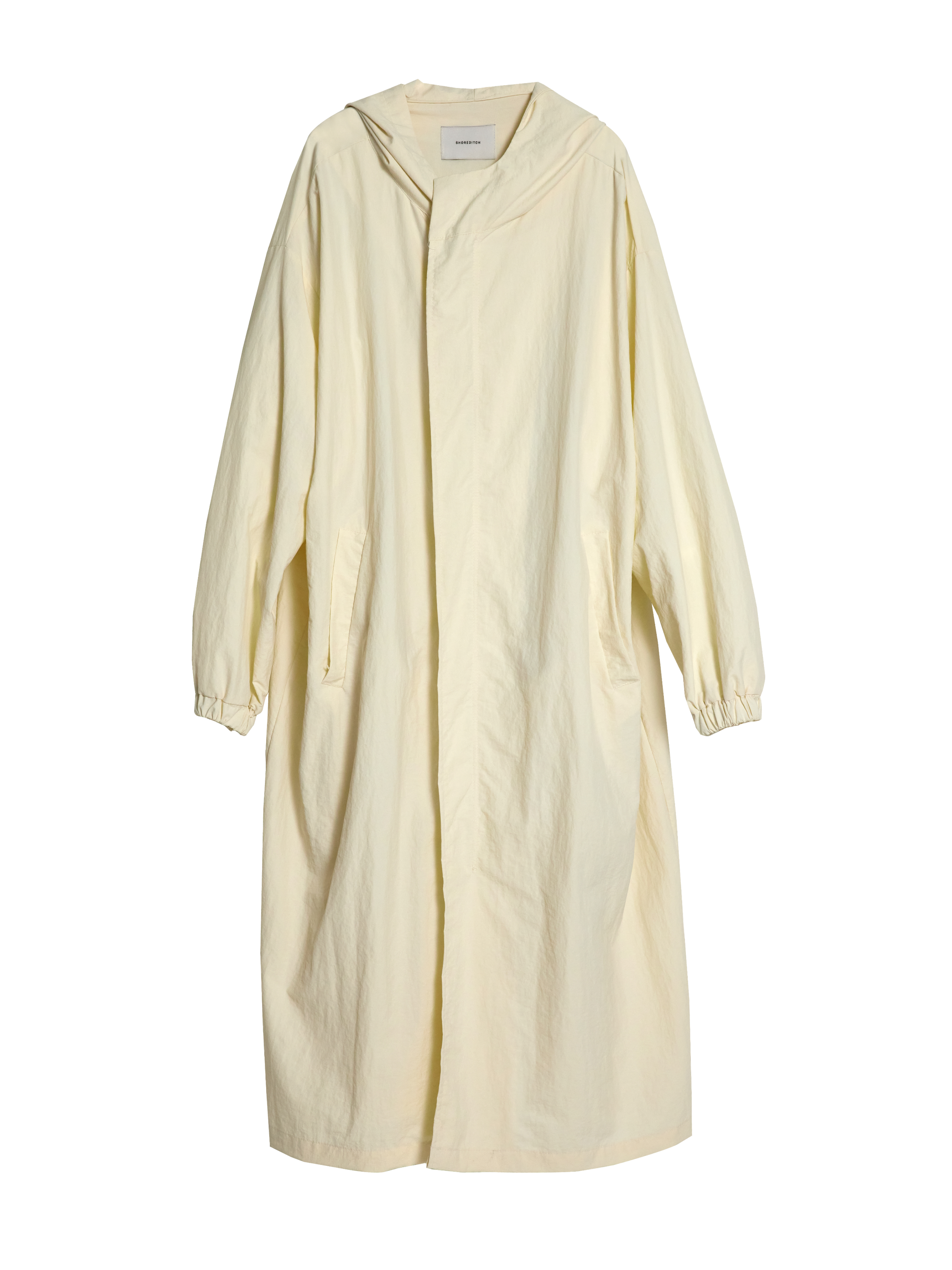 It captures the front side of the cream long coat with the white backdrop.