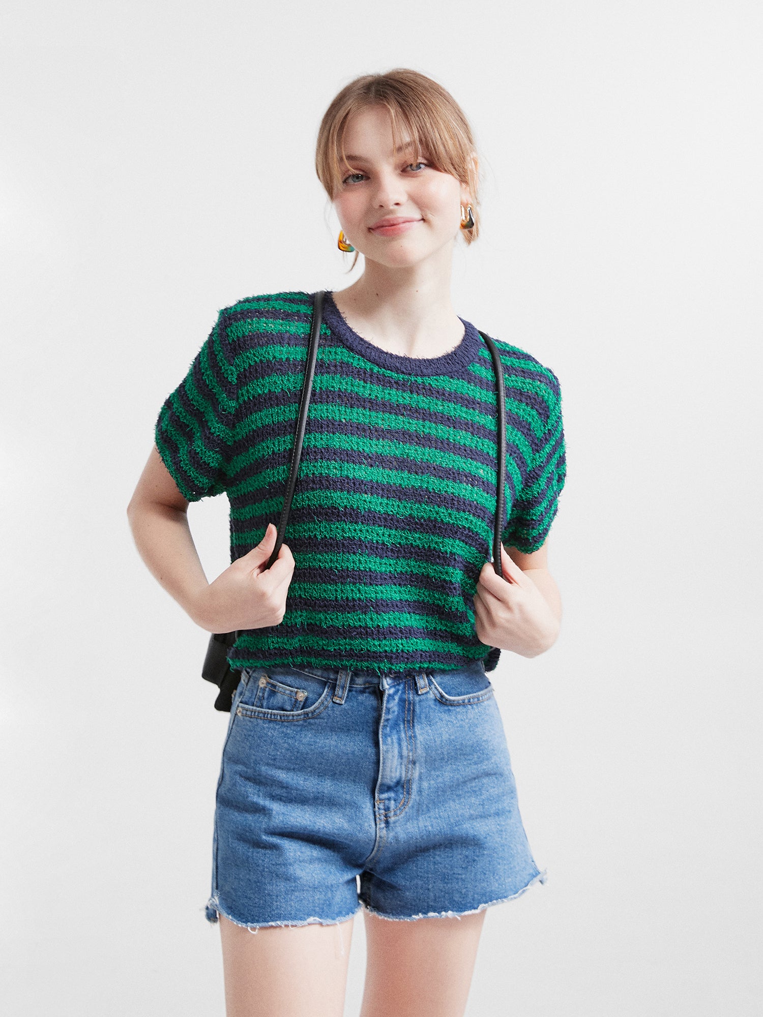 Front shot of the model wearing the jean shorts matching with the striped short sleeve knit.