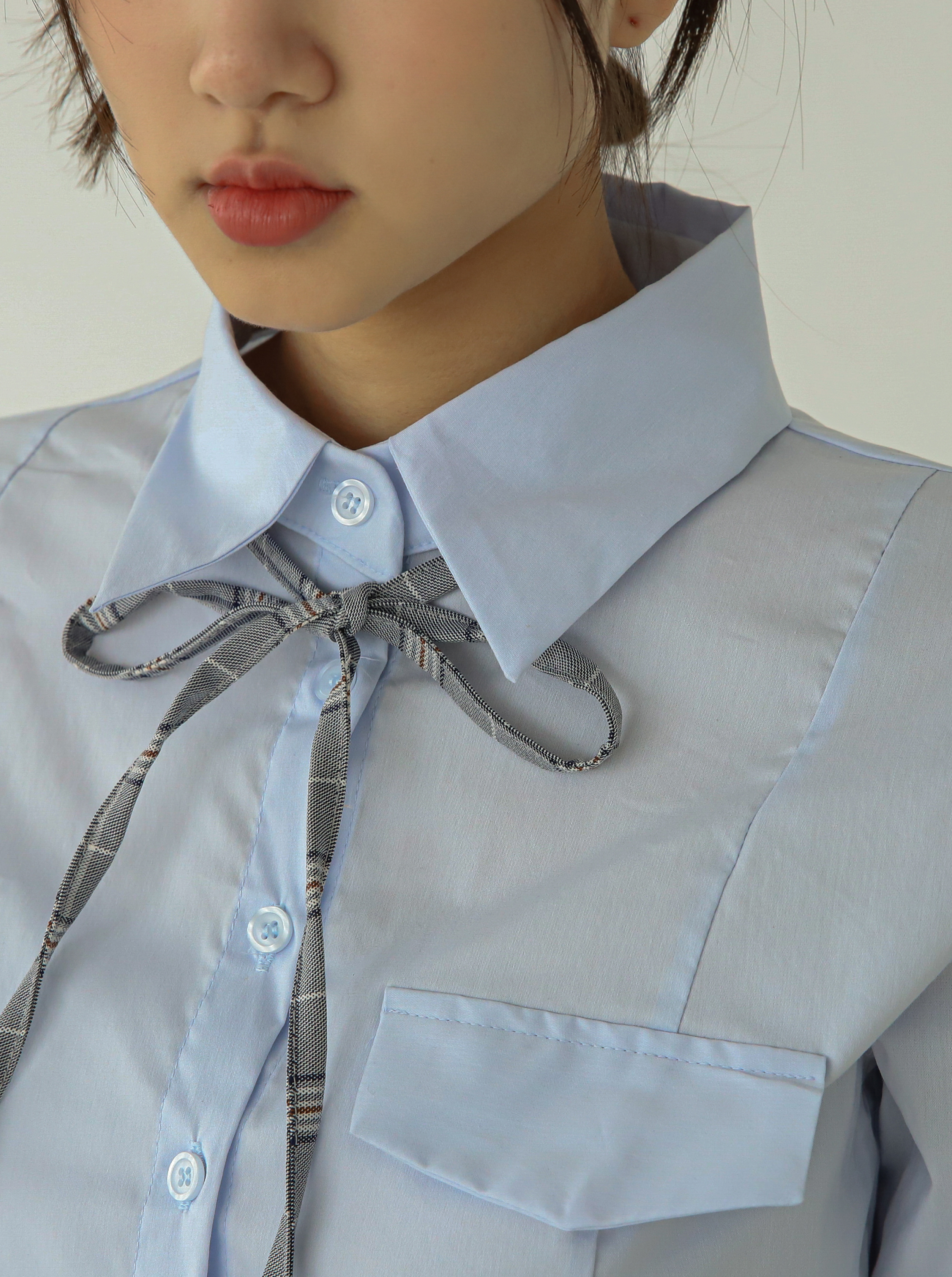 This is a zoomed-in shot highlighting the intricate laced and design seams of the collar shirt.