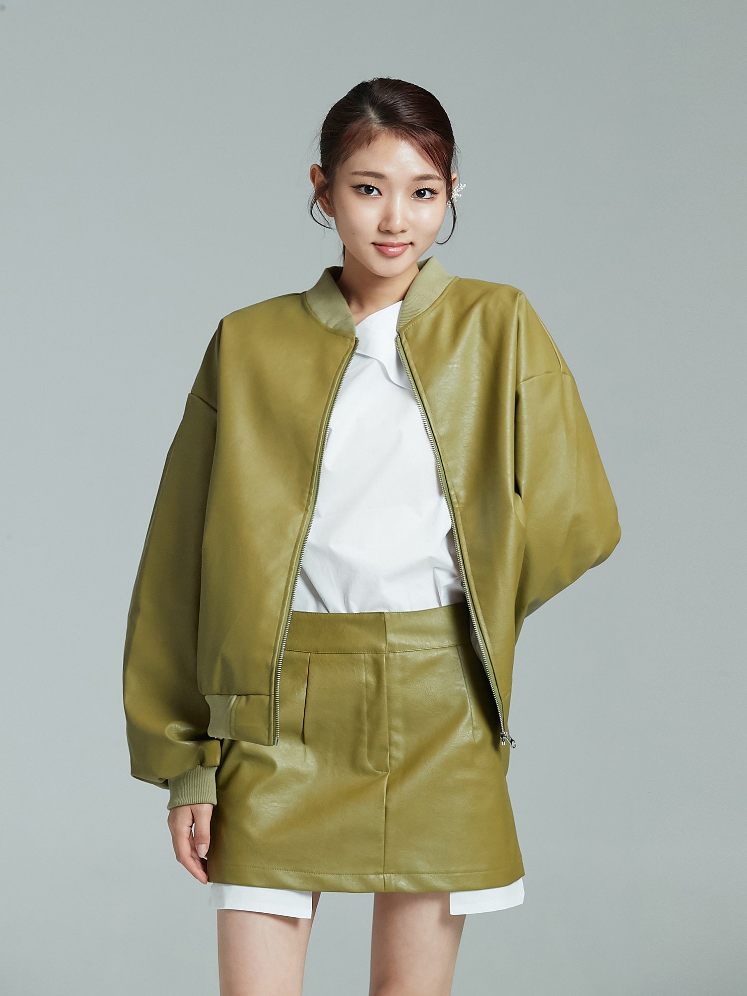 Front shot of the model wearing the leather bomber jacket and mini leather skirt set to showcase its korean street fashion vibes.