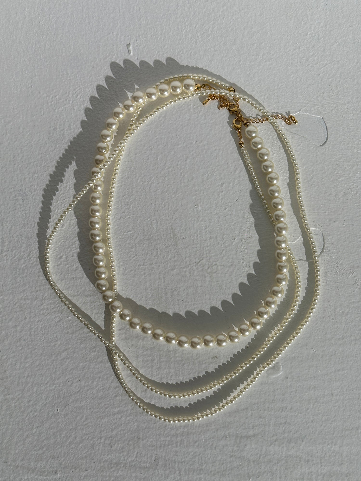 A detailed view of the long pearl strand necklace showcasing the intricate designs inspired by South Korean fashion.