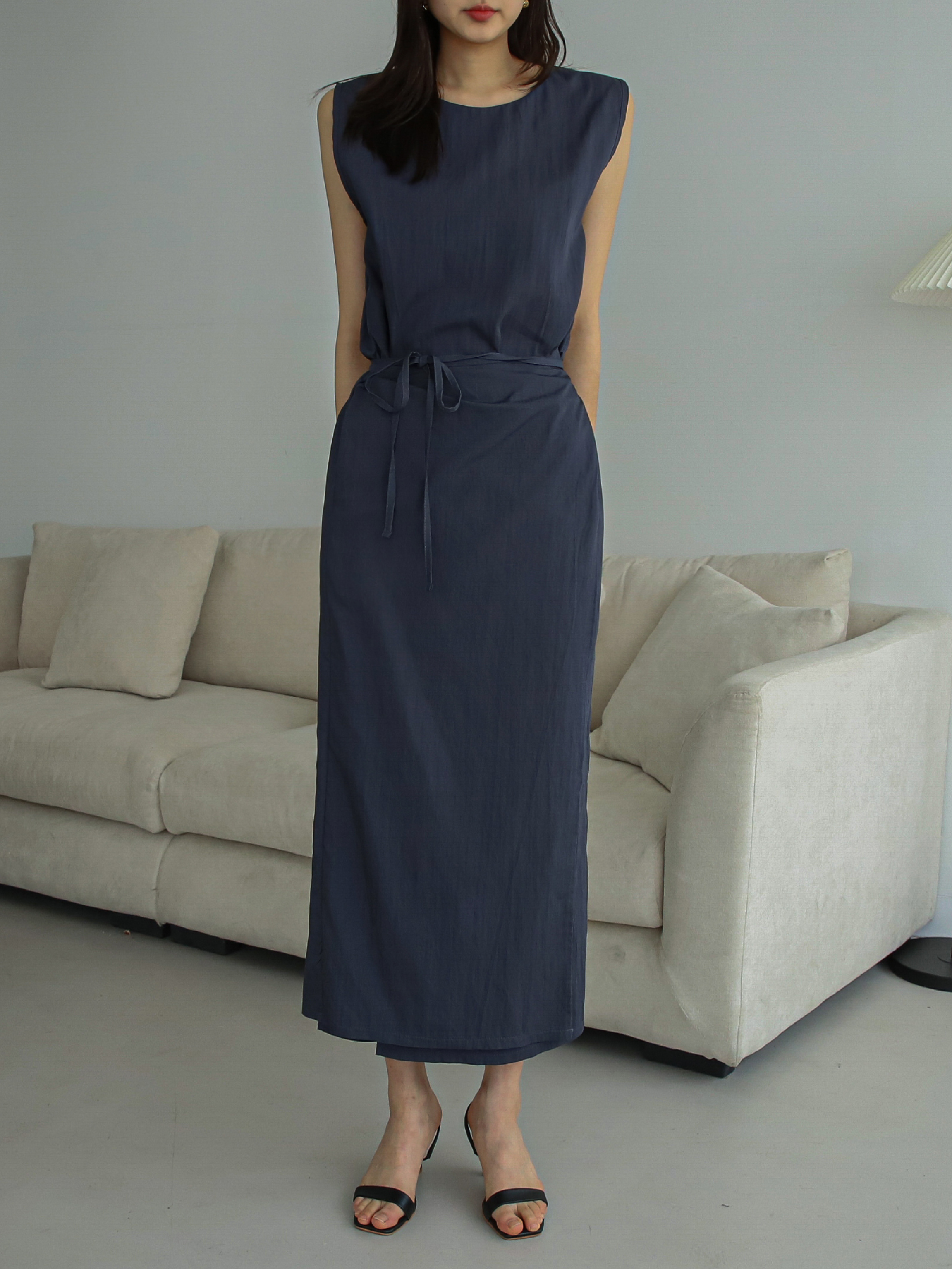 Shoulder-to-toe shot of a model wearing a navy maxi wrap dress that highlights the full-length.