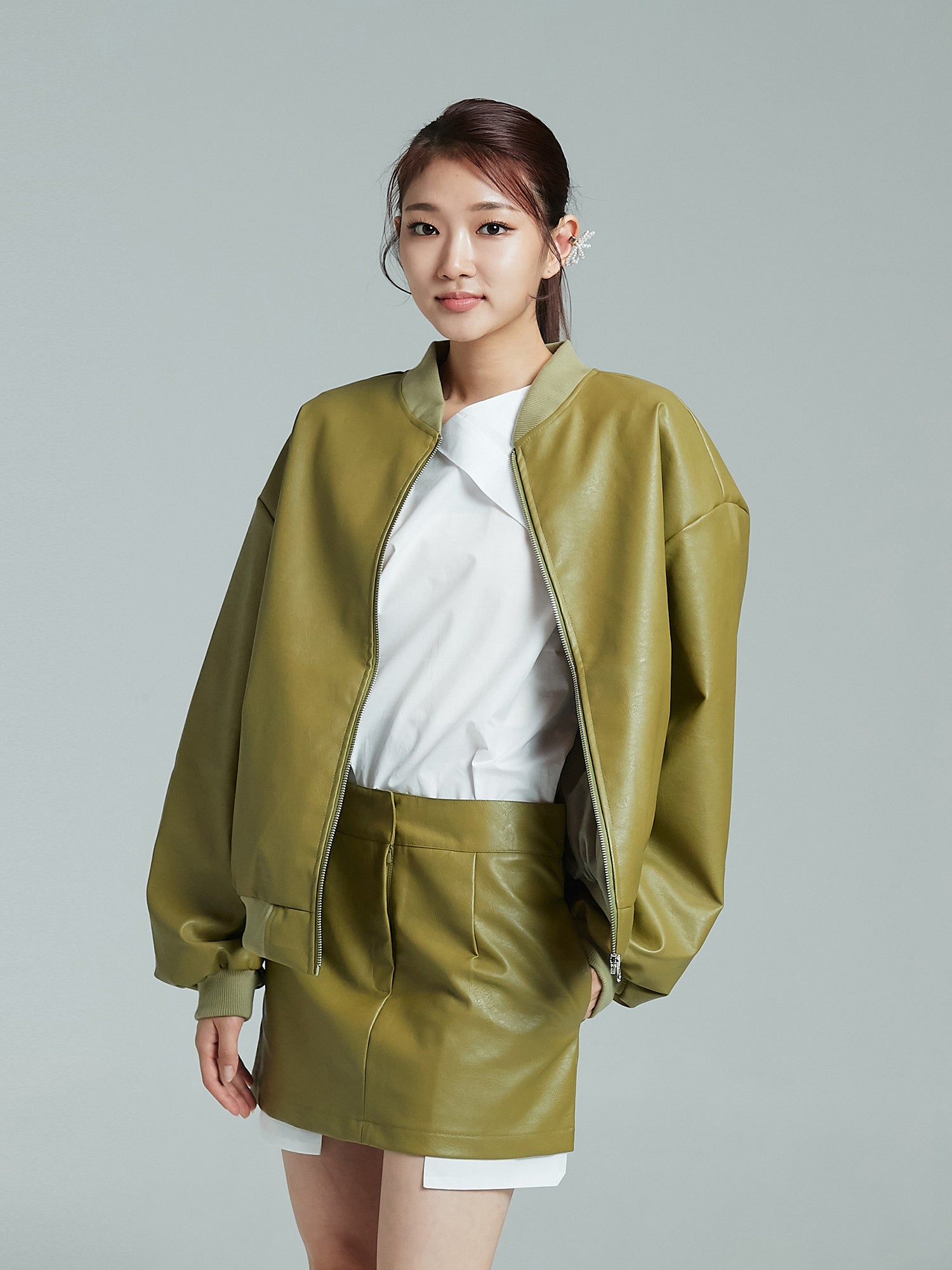 An angled view of the model donning the mini leather skirt, elegantly highlighting its Korean street fashion appeal.