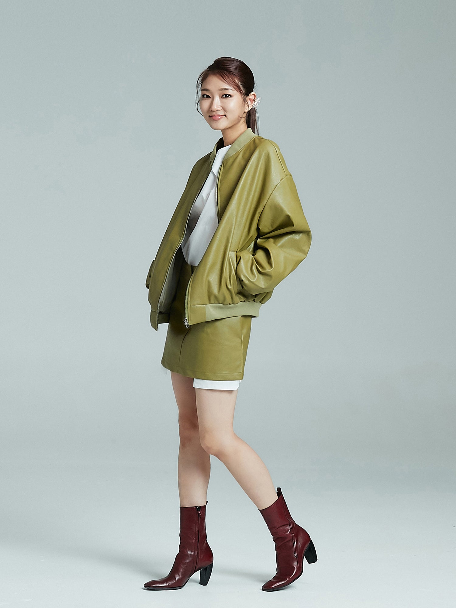 A sideways glance at the model showcasing the mini leather skirt with a touch of Korean street fashion.