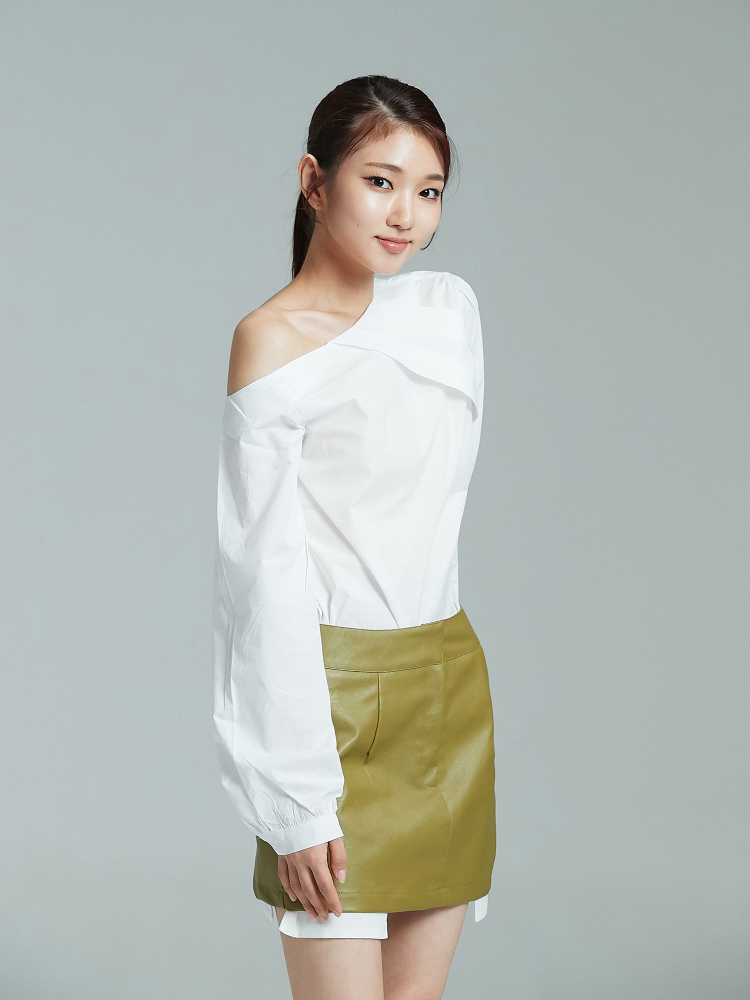 Side angle of the model wearing the one shoulder blouse showing the side look of the blouse.