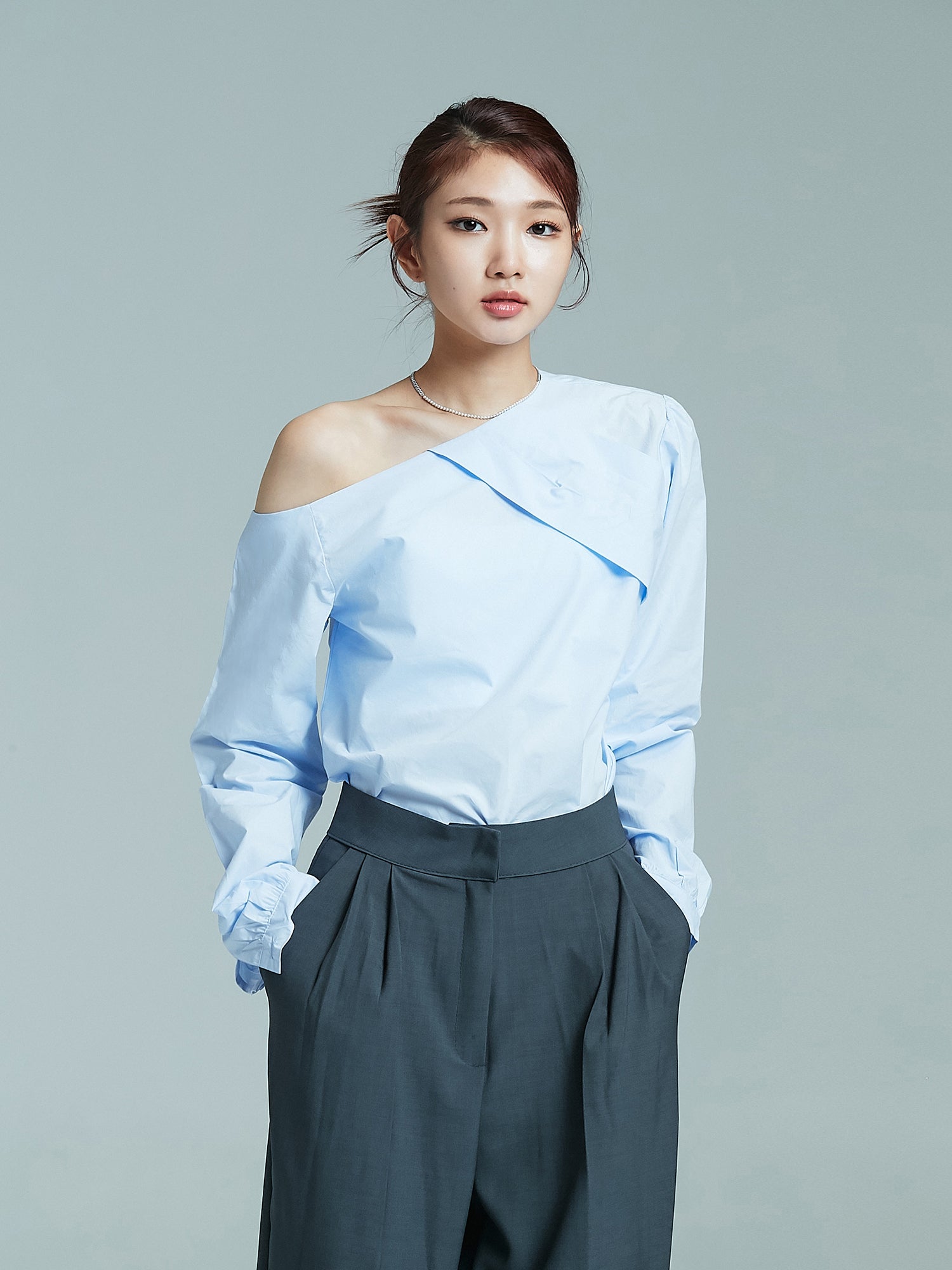 Front shot of the model wearing the light blue one shoulder blouse showcasing the south korea fashion.